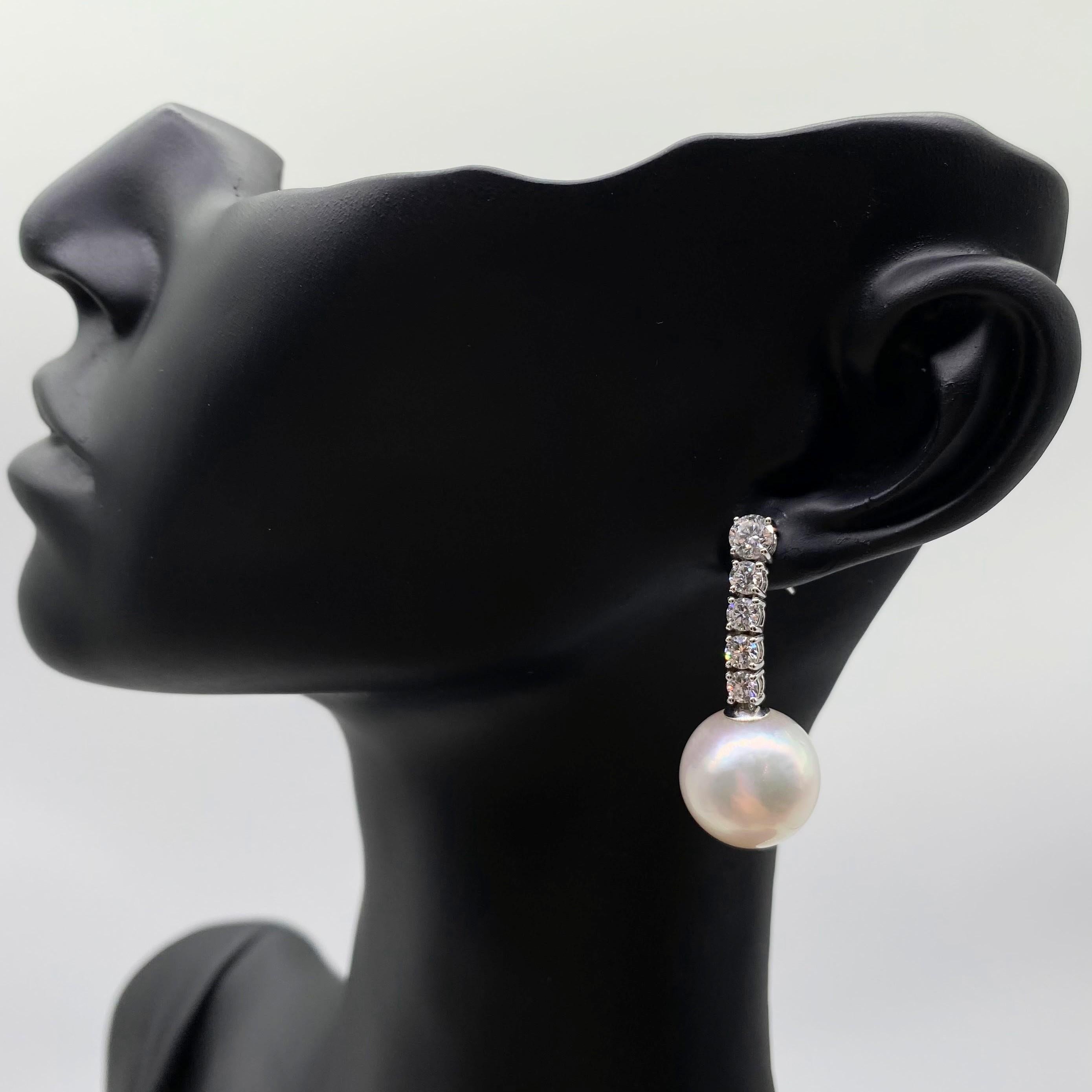 Exuding sophistication and luxury, these 13mm South Sea Pearl Diamond Drop Earrings in 18K White Gold are a stunning addition to any jewelry collection. The centerpiece of each earring is a natural white South Sea pearl, measuring approximately