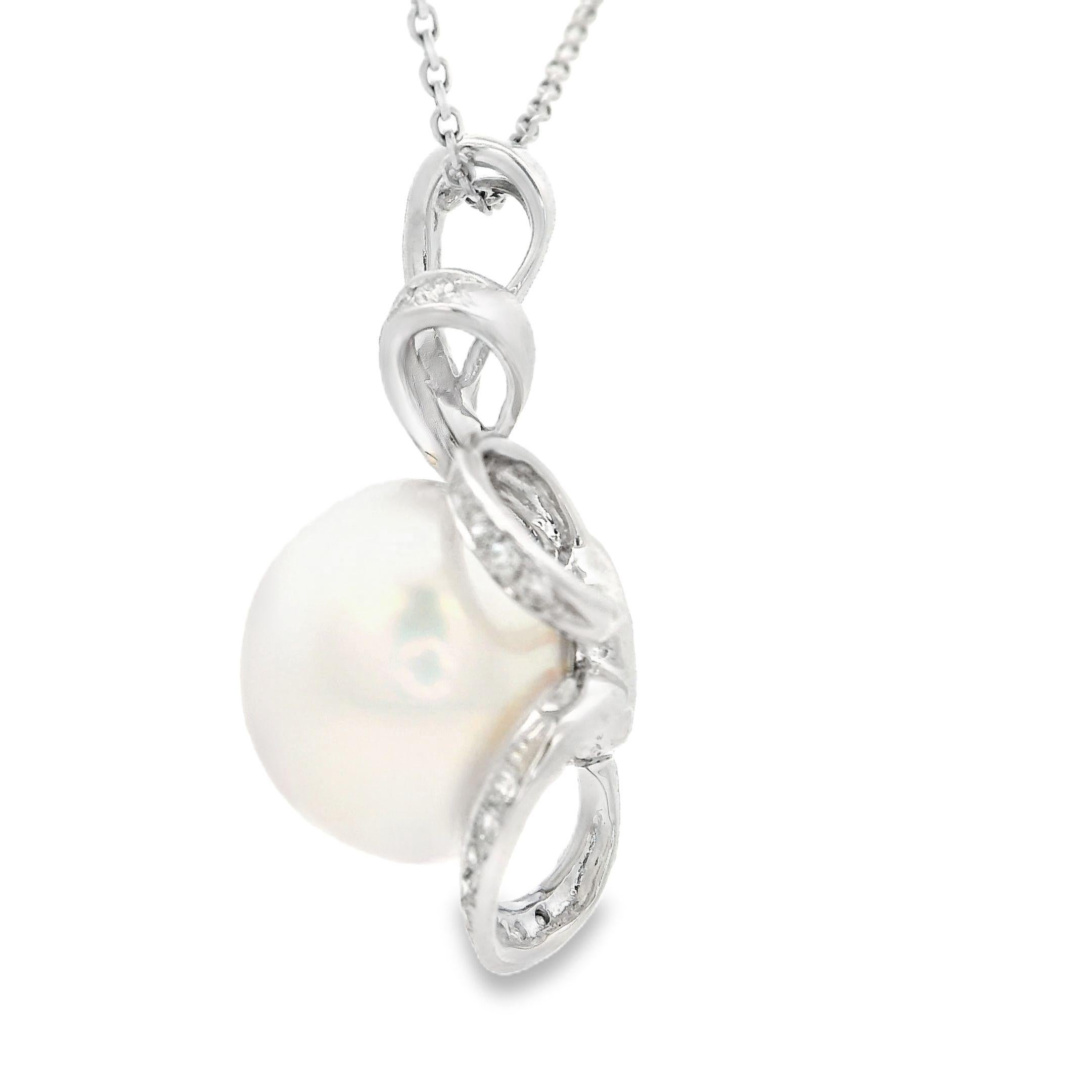 Eleganza senza tempo con questo squisito ciondolo, meticolosamente realizzato in oro bianco 18 carati. Al centro di questo design c'è una lucente perla South Sea da 13 mm, rinomata per la sua radiosa lucentezza e la sua bellezza classica. La