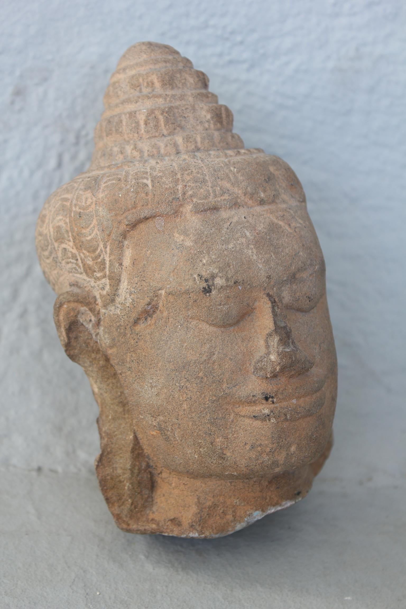Buddha head sculpture in sandstone, Angkor temple, 13th century.
Authentic piece, appraised.
Dimensions: Height 15.5cm, depth 8cm, width 9cm