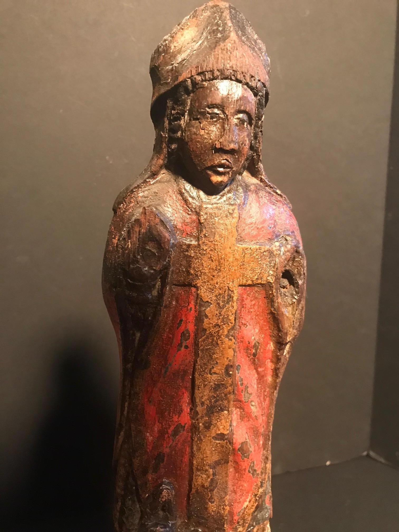 A most rare and imposing 13th century devotional English black oak carved sculpture of a Bishop Saint. It is a magnificent and extremely rare survivor of the 13h century. This fine example is hand carved from a single piece of heavy dark brown