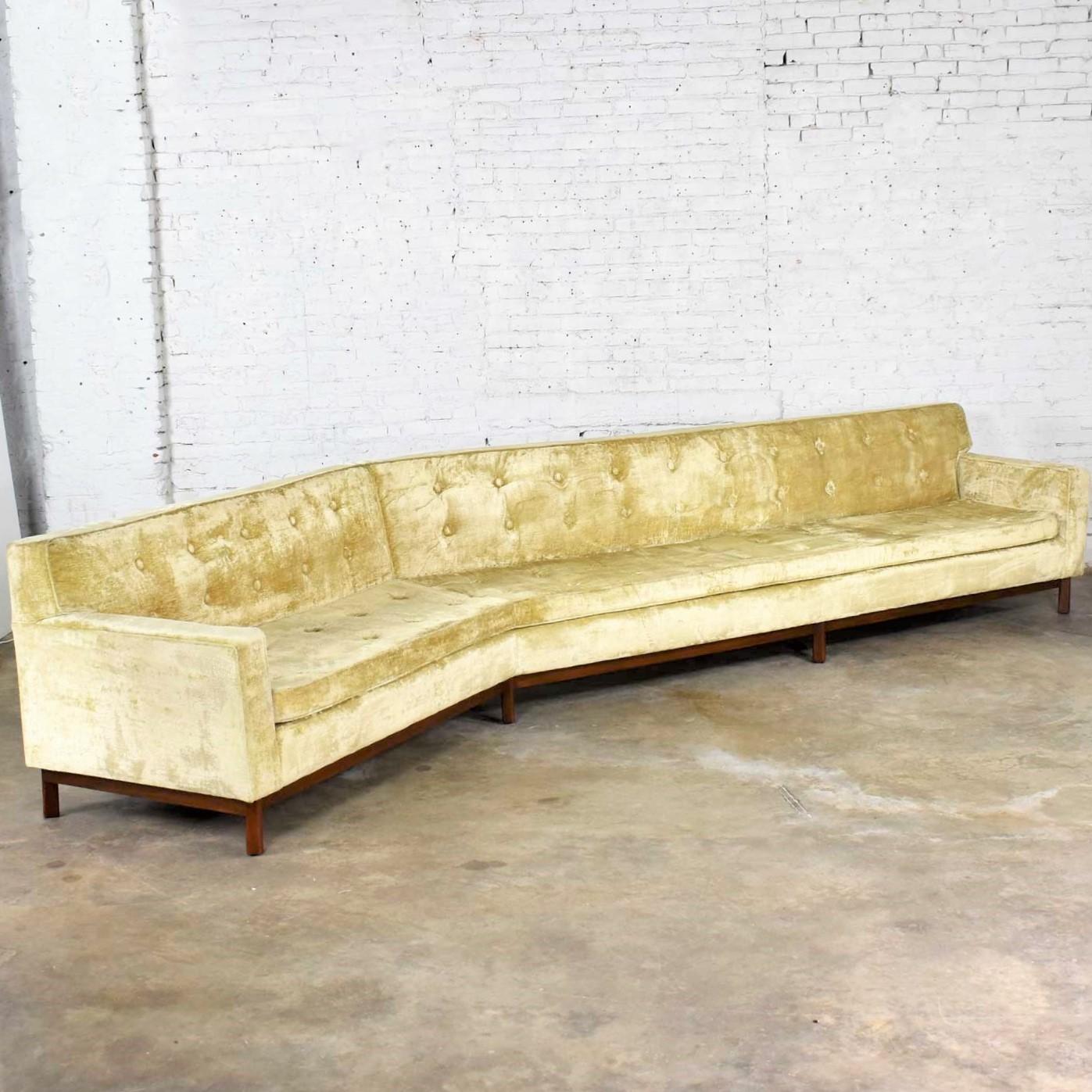 Wonderful and monumental 14-foot-wide angled Mid-Century Modern green velvet sofa in the style of Edward Wormley for Dunbar. It is in good vintage condition. It has been professionally cleaned and the fabric is presentable. No holes or worn spots
