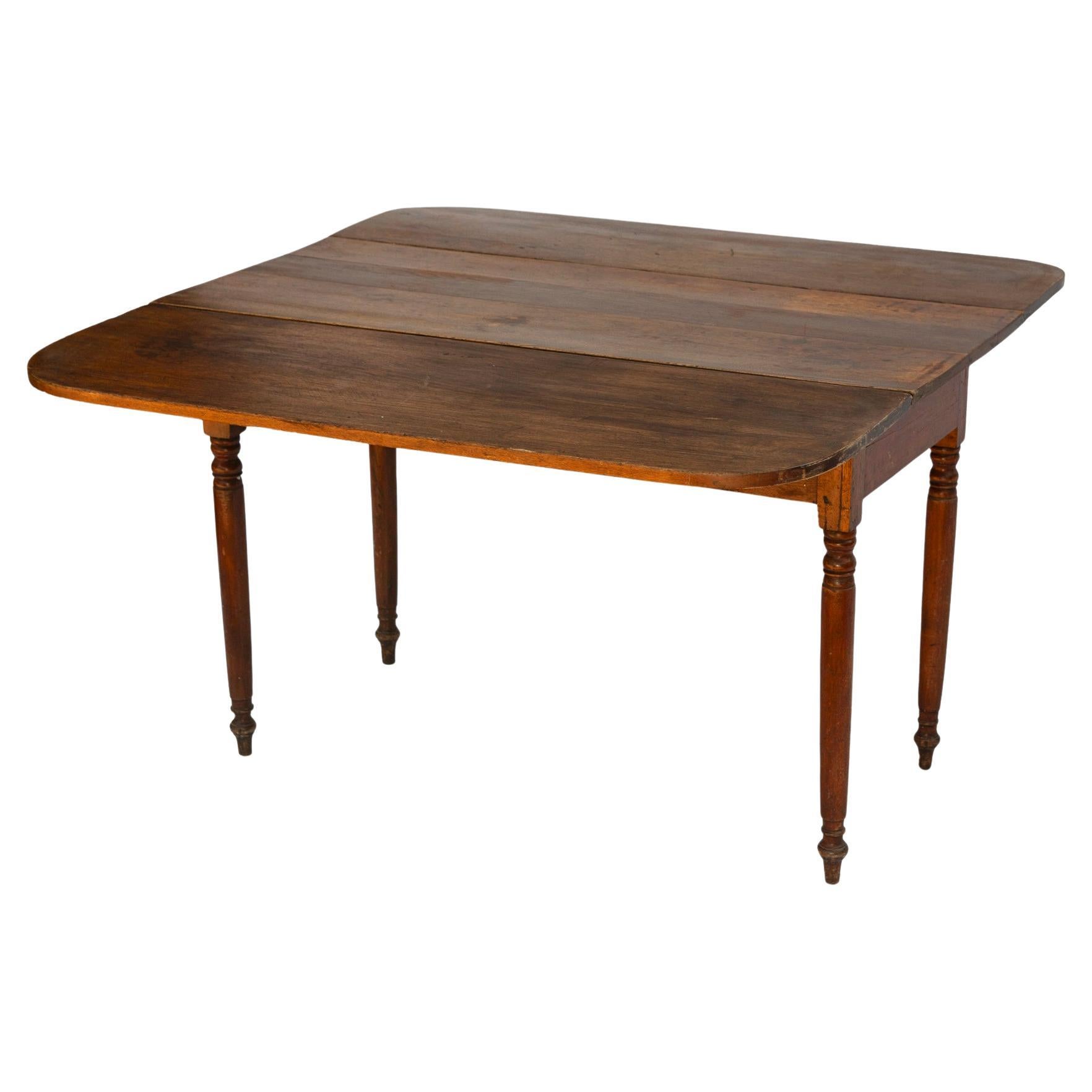  Antique Solid Cherry Drop-Leaf Farmhouse Table, dating back to the 1800's..
Turned legs with a three board top having rounded corners.
Original hinges, in good condition.
Beautiful older finish with rich patina.
Restored, yet left with its original