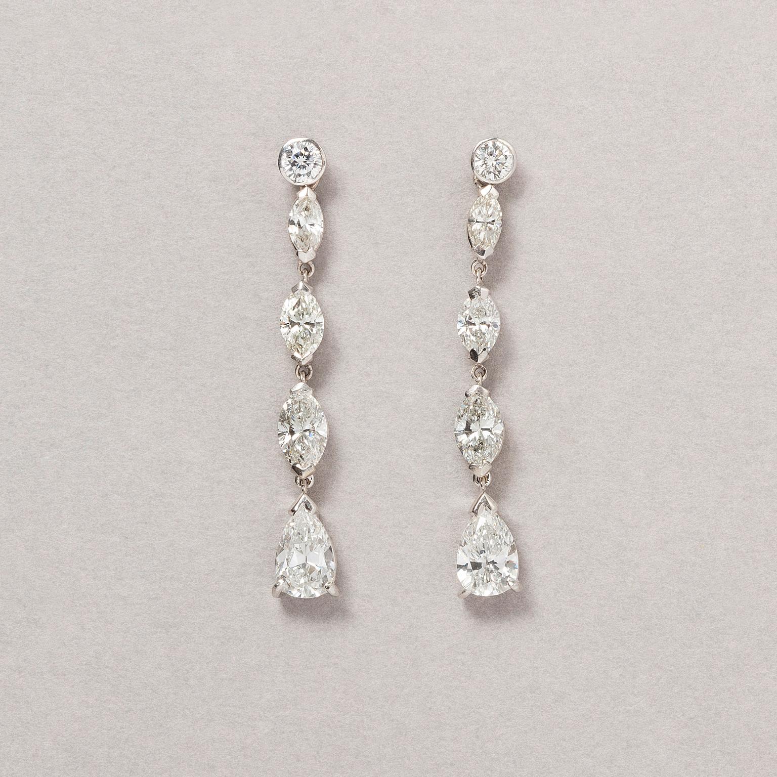 A pair of 14 carat white gold earrings set with a brilliant cut diamond on the stud, followed by three navette cut diamonds, increasing in size with a dangling pear cut diamond on the bottom (app. 2.86 carat in total, Si, VS, VVS, F-G color with the
