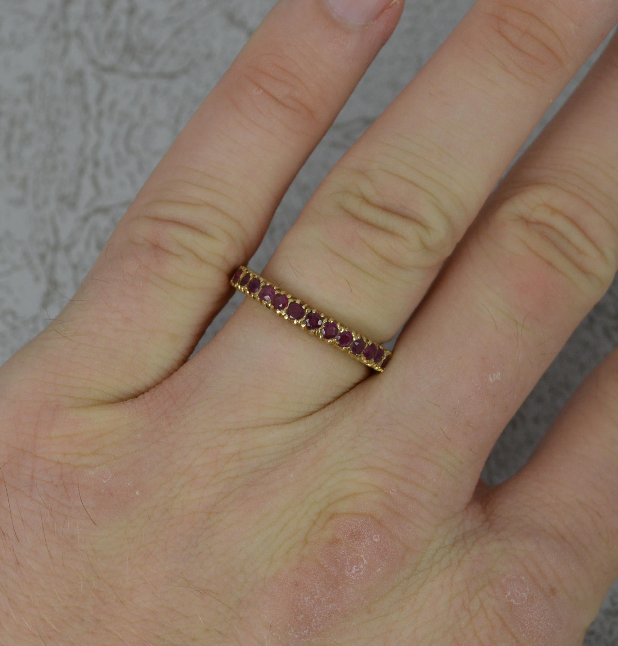 A 14 carat yellow gold and ruby ring.
Full eternity band comprising of over 30 natural round cut rubies.
3mm wide band throughout. Protruding 2.9mm off the finger.

CONDITION ; Very good. Well set stones, issue free. Clean and crisp design. Please