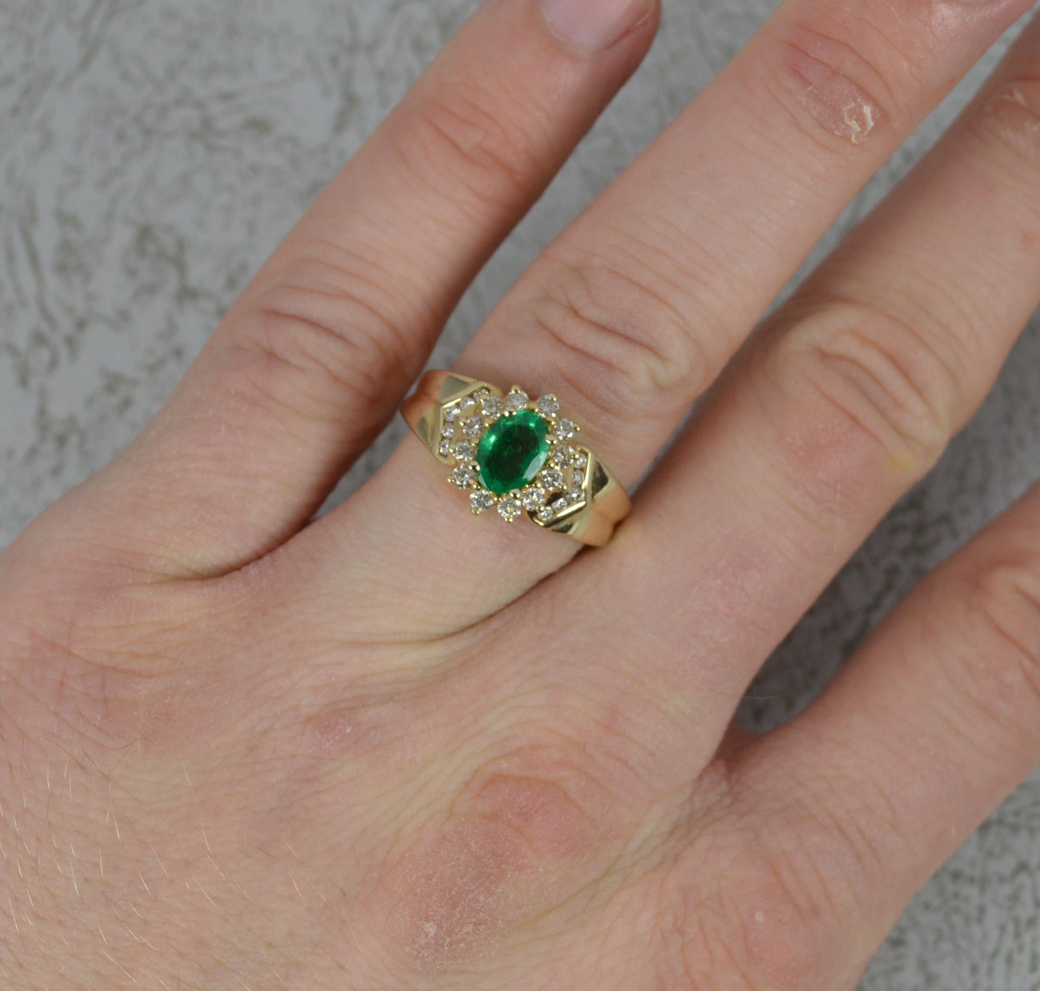 A 14ct gold, emerald and diamond ring.
Solid 14 carat yellow gold example.
Designed with an oval cut emerald to centre in four claw setting. 5mm x 7mm. Surrounding are twelve natural round cut diamonds with a further five diamonds to each