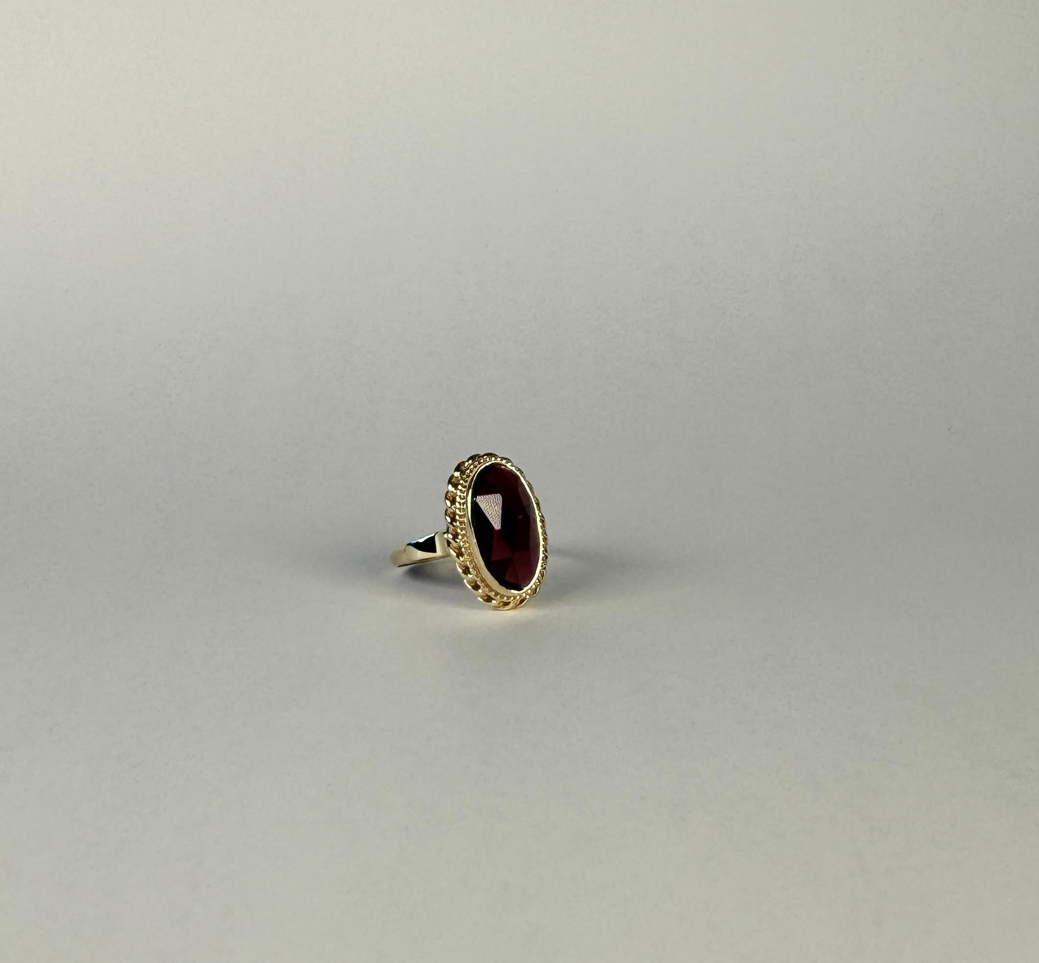 Oval Cut 14 carat gold ring with a beautiful faceted garnet  For Sale