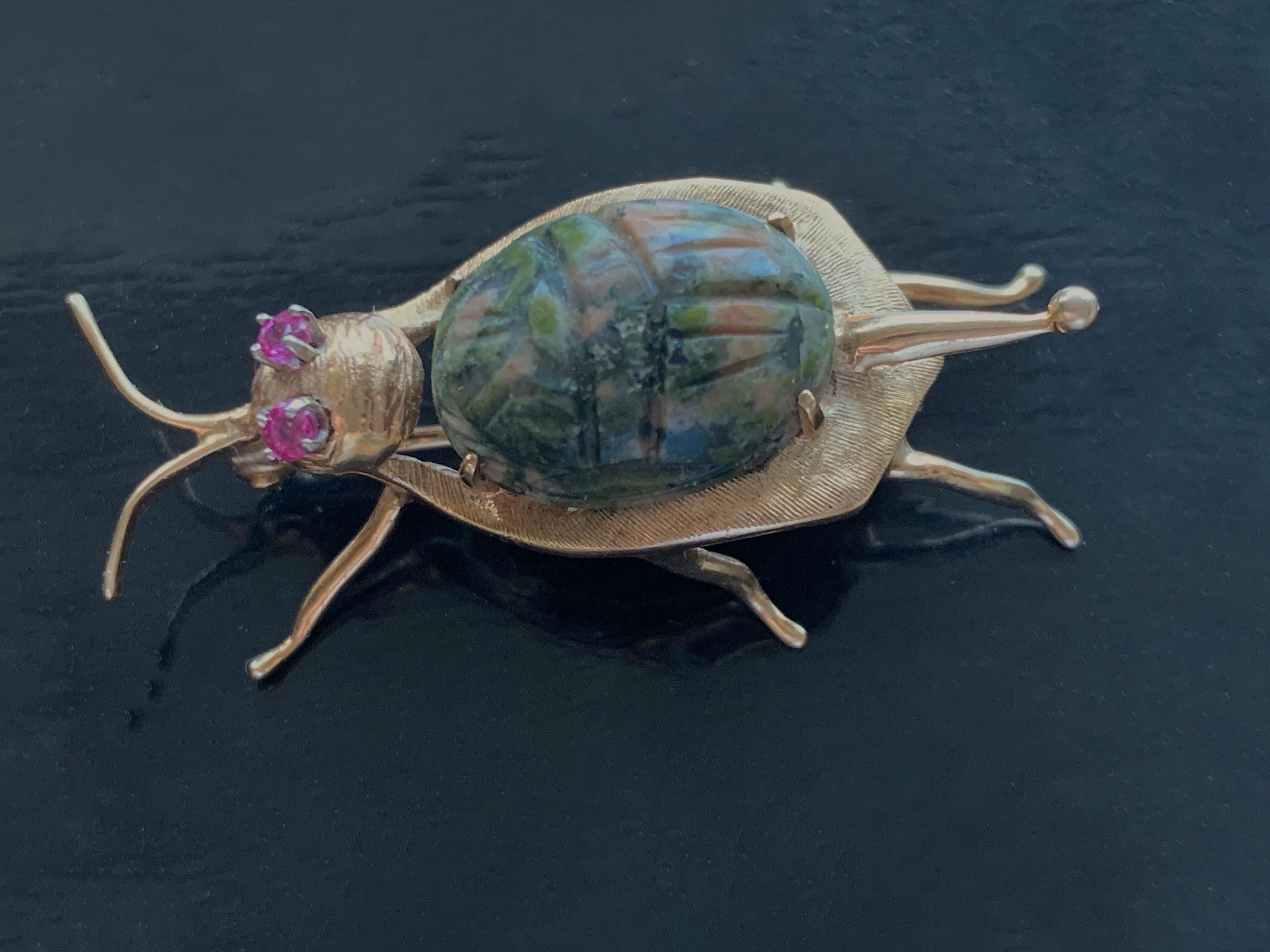 Delightful beetle brooch
created in 14ct Gold 
with pink ruby eyes set in platinum
Beetle  holds a hand carved natural Stone 
which has natural pink , blue & green hues.
Marked 14k & makers stamp on the pin.
fastening is in excellent condition.