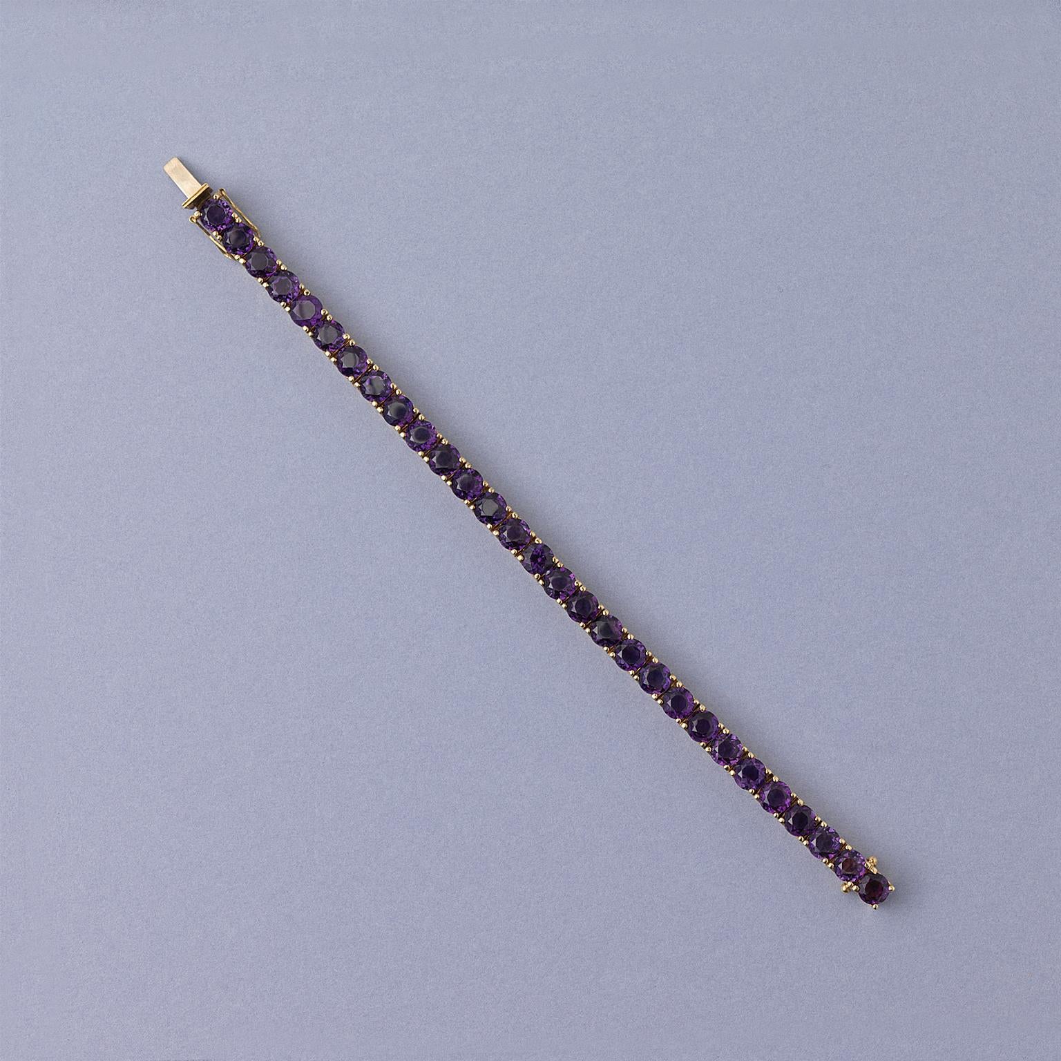 A 14 carat gold line/ tennis bracelet set with 29 round facetted deep purple amethysts.

weight: 30.8 gram
length: 18 cm
width: 0.6 cm
