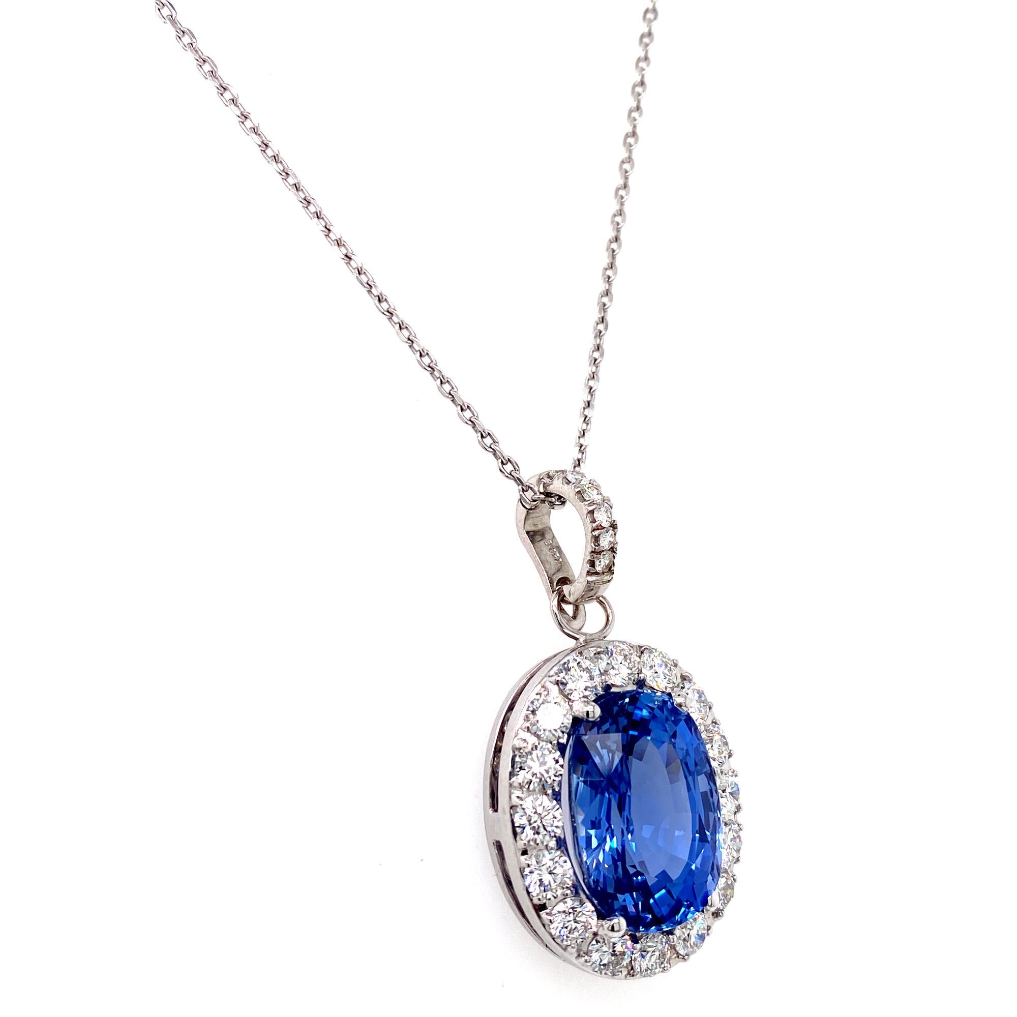 The most beautiful color Blue Sapphire and diamond pendant is fashioned in 18 karat white gold. The 14.48 carat oval no heat Ceylon blue sapphire is surrounded by round brilliant cut diamonds weighing 2.50 carat total weight. The diamonds are graded