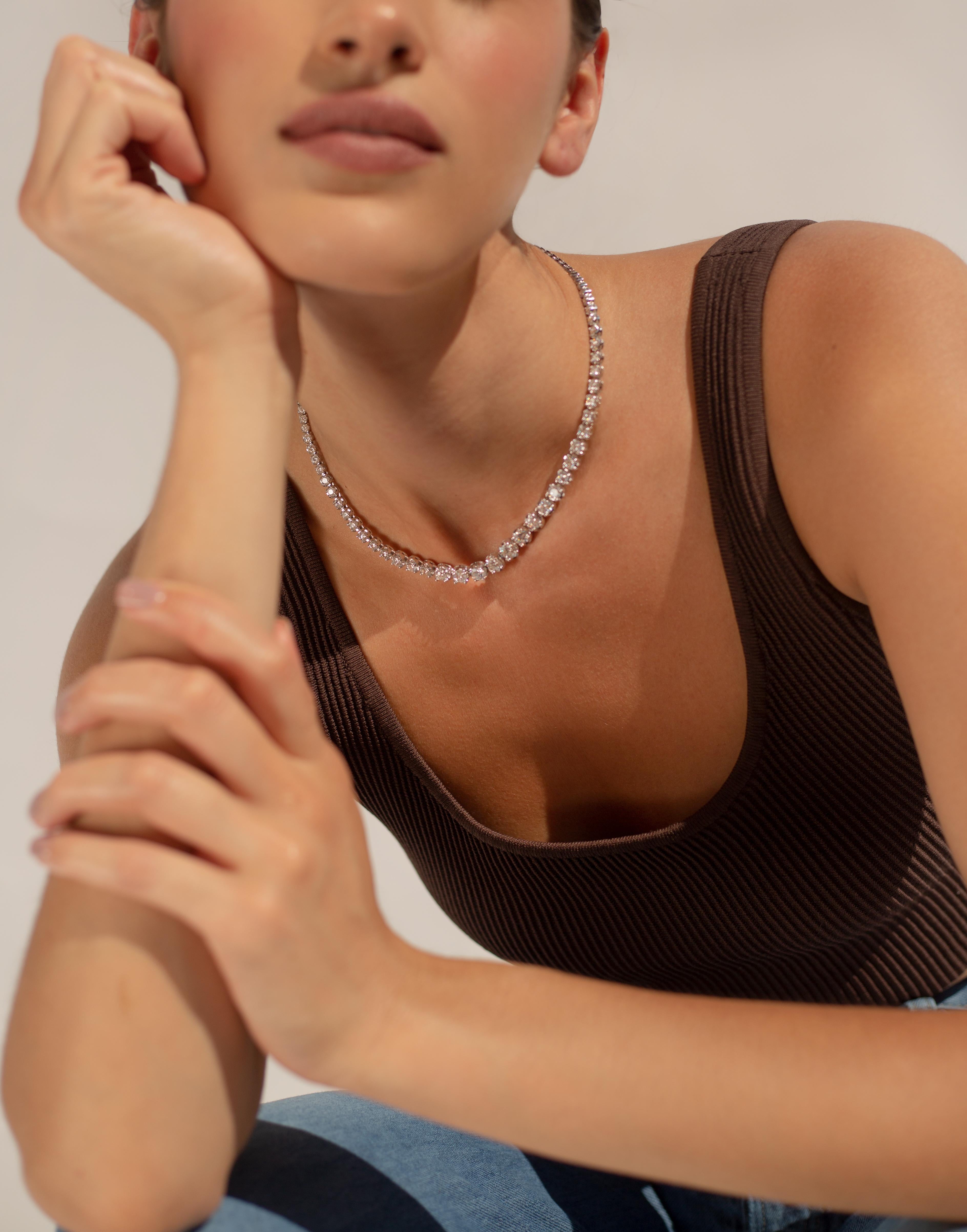 This graduated  set tennis necklace is a classic piece that never goes out of style.  
Available in 14K White Gold, Yellow Gold, or Rose Gold
Diamond quality is G-H, SI
Diamond weight = 14 carats
Center stone weight = 0.87 carats
Necklace length =