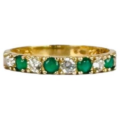 Anillo bang de oro amarillo de 14 quilates con zafiros blancos y esmeralda de 0,16 quilates