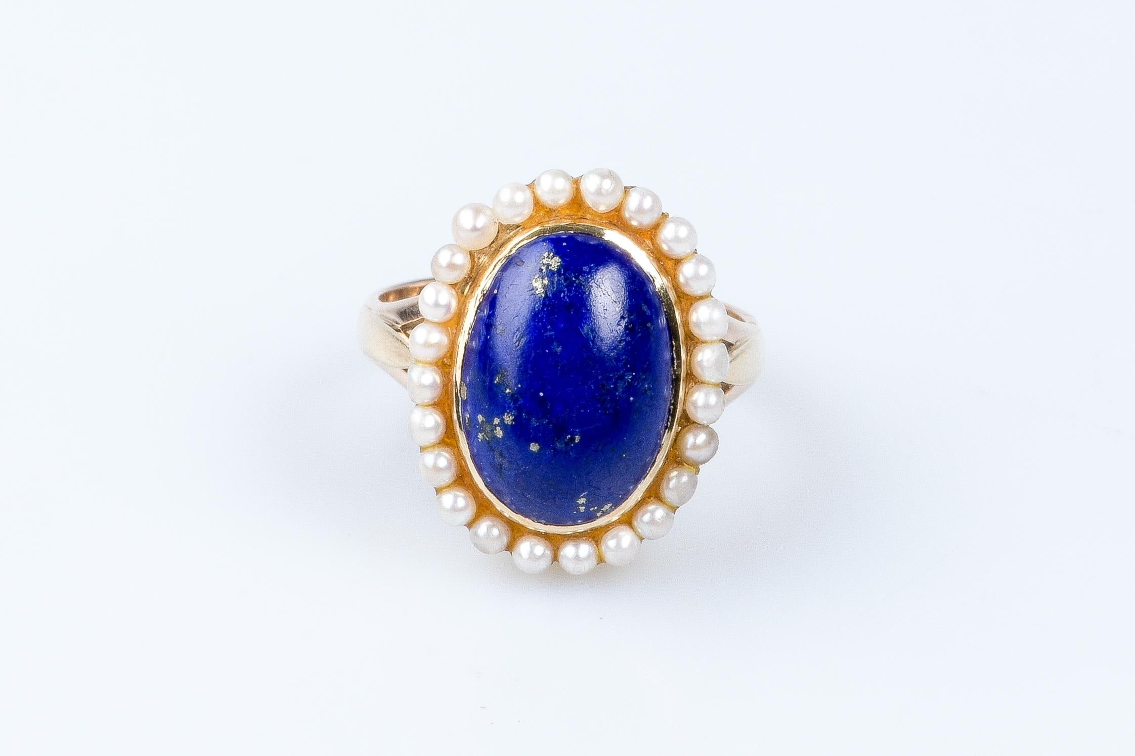 14 carat yellow gold ring designed with 1 oval lapis lazuli weighing 2.20 carats surrounded by 24 round white cultured pearls.

 Weight : 7.60 gr. 

Size: EU : 53  - SP/IT : 13 - US : 6.5

Dimensions : 1.92 x 1.50 x 0.35 cm

Jewel delivered in a