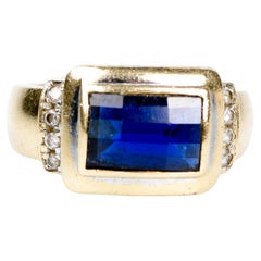14-carat yellow gold ring with 8 round-cut diamonds and a rectangular sapphire