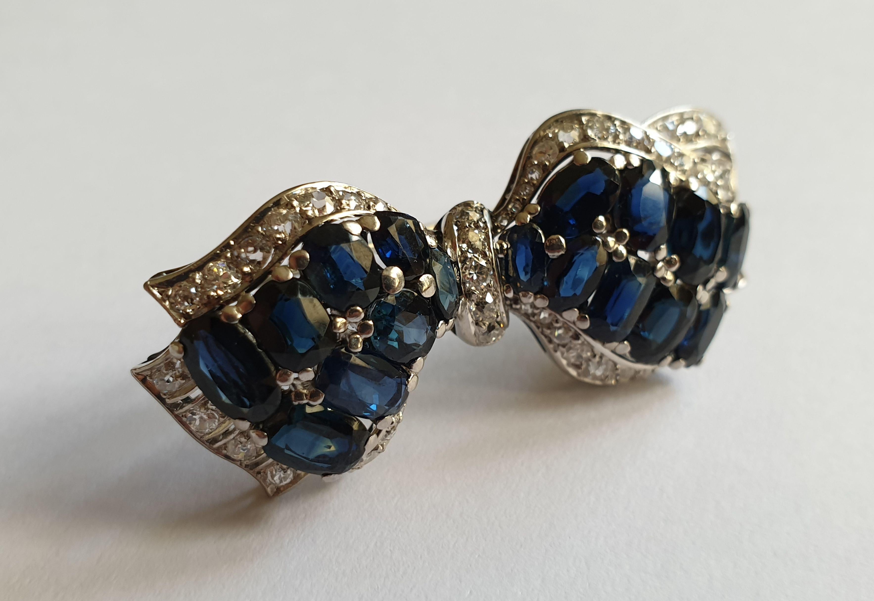 Germany, 1970s. Bow-shaped front with 17 oval-cut sapphires weighing total 9,50 ct. Surrounded by 56 brilliant-cut diamonds weighing total circa 1,50 carats SI, wesselton. In 14 ct. white gold. Hallmarked with the purity 585. 
Weight: 13,9 grams.