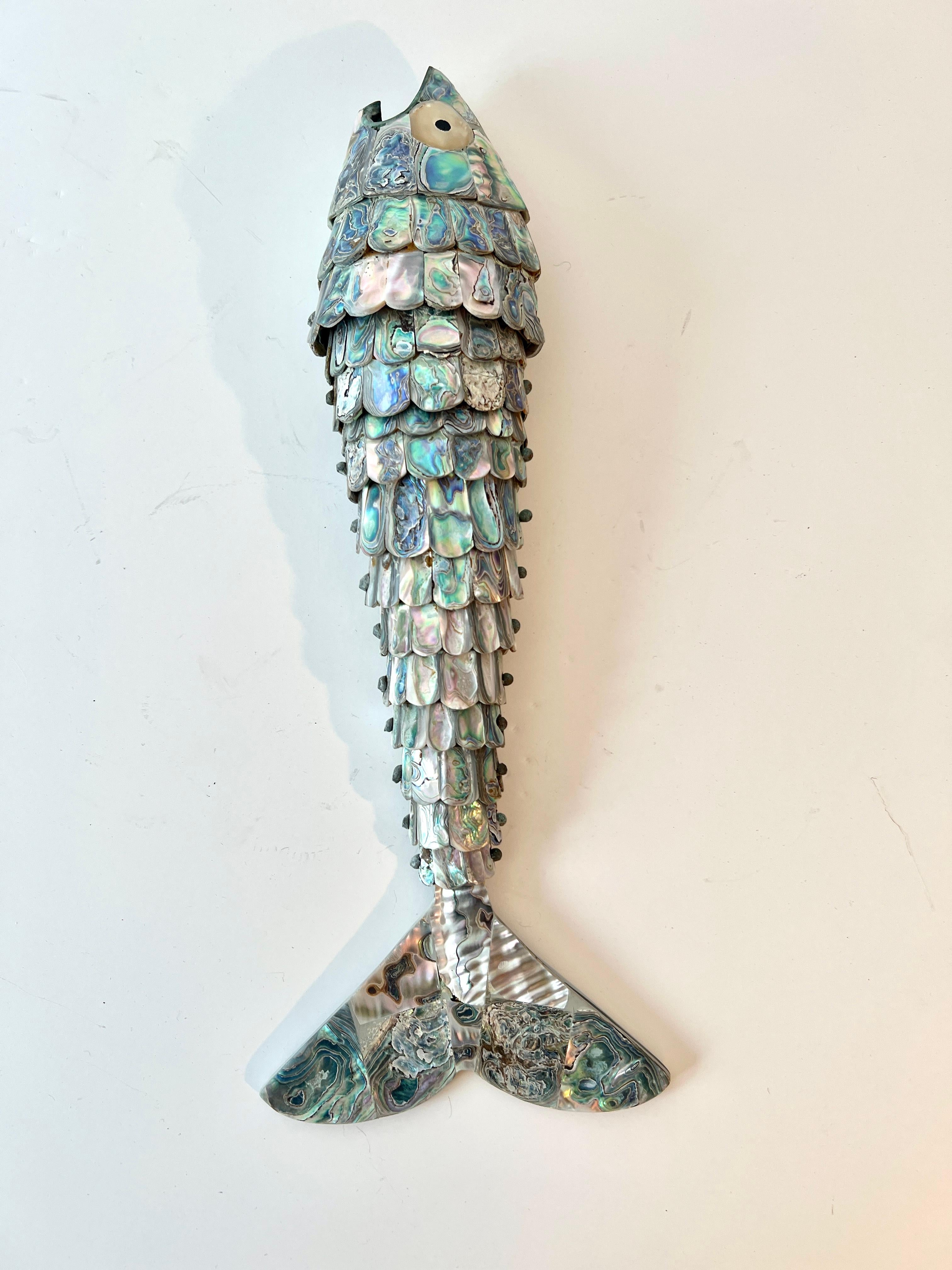 A Mexican Mid-Century Abalone Bottle opener in the style of Los Castillo.

We have sold many of these unique fish bottle openers and, at 14 Inches,  this is one of the largest we have seen.  The piece can stand up on its tail and be the conversation