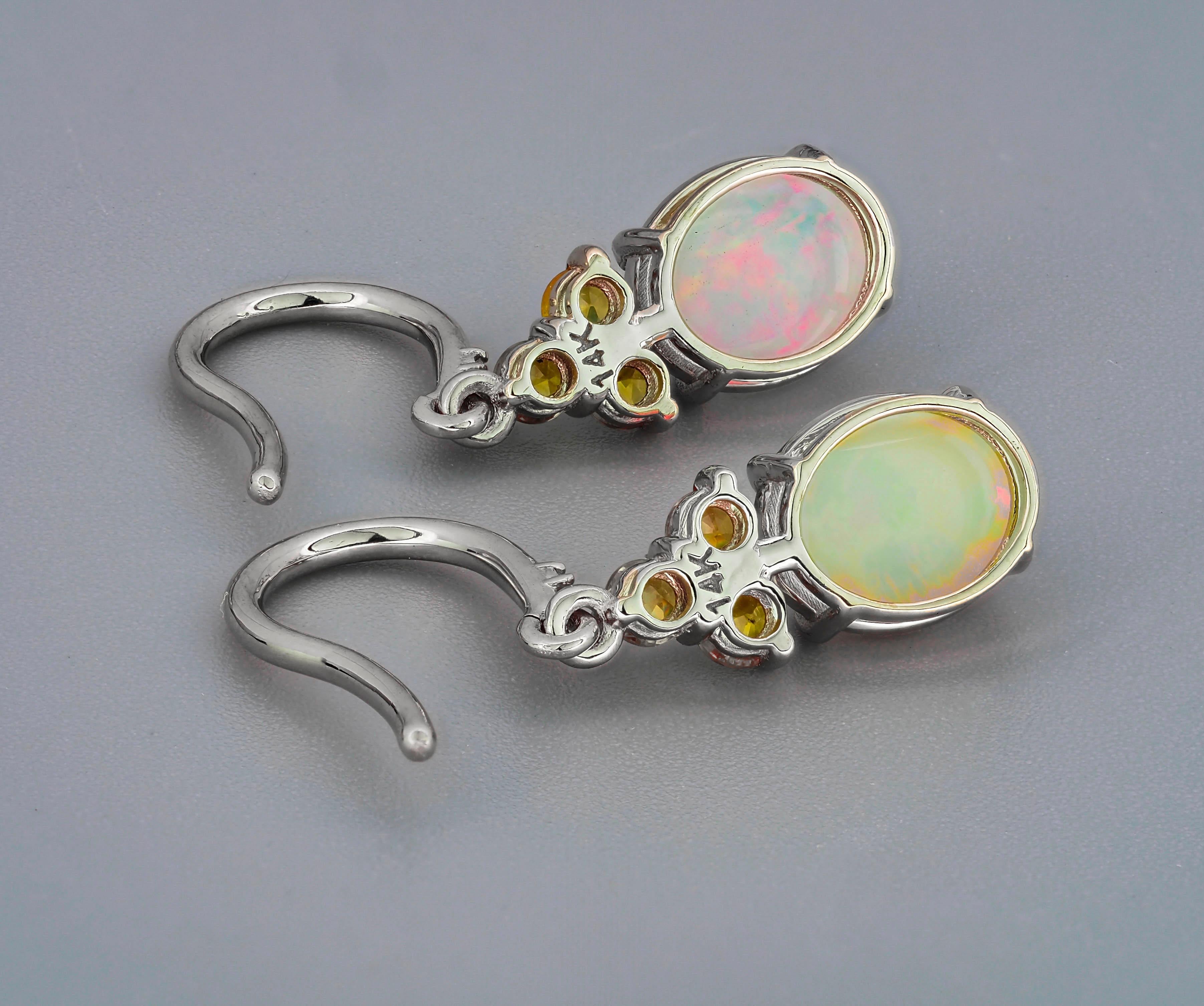 14 kt solid gold earrings with central natural opal, diamonds and sapphires. October birthstone.
Size: 25 x 6 mm.
Total weight: 2.5 g.

Central stones: Natural opals 2 pieces
Weight: approx 5.00 ct in total (8.5 x 6 mm each), oval cut
Clarity:
