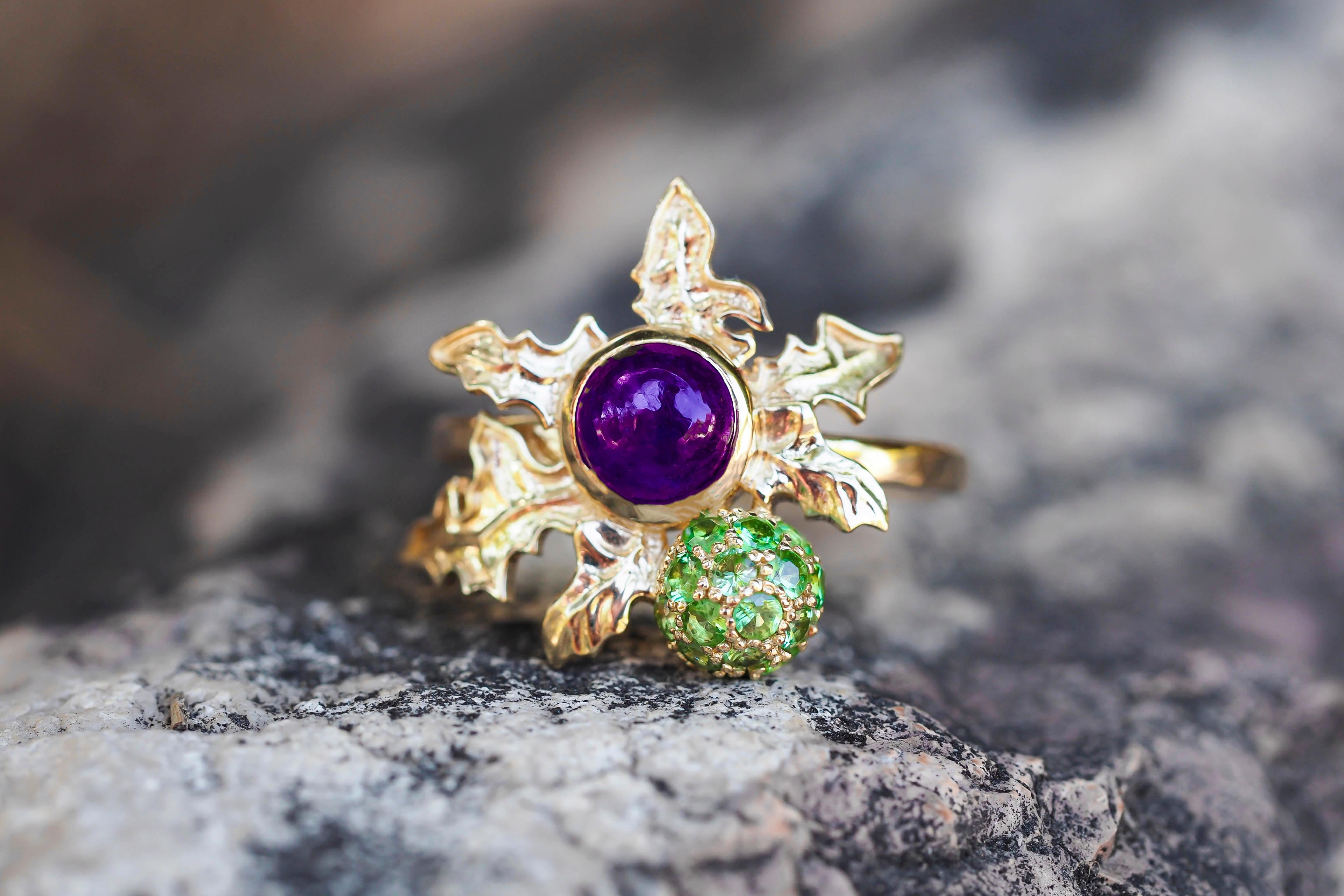 14 kt  gold ring with amethyst and peridots. Scottish thistle gold ring.
Weight: approx. 2.85 g. 
Set with amethyst, color - purple
cabochon cut, 1,2 ct. in total, 6 mm
Clarity: Transparent with inclusions  
Surrounding stones: peridots, round cut,