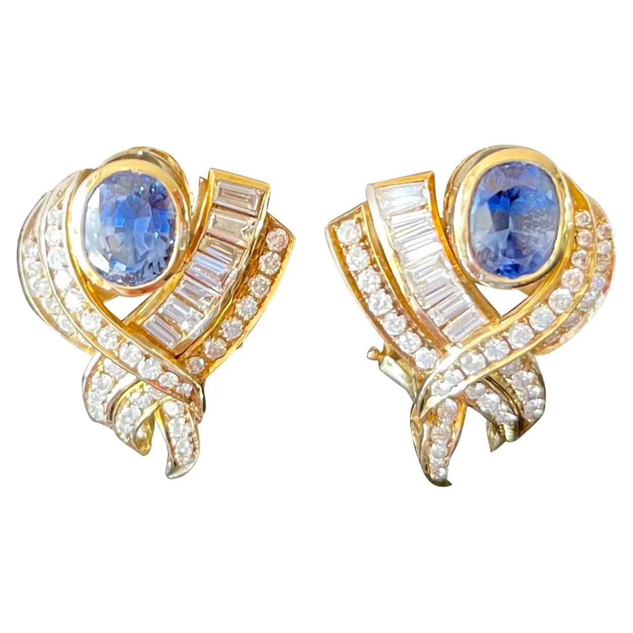 Captivating cockatail earclipsin 14 K yellow Gold featuring 2 lovely blue bezel set oval Sapphires weighing approximately 3.60 ct framed by Baguette and Brilliant cut Diamonds weighing approximately 4 ct. 
Images do not always reflect the true color