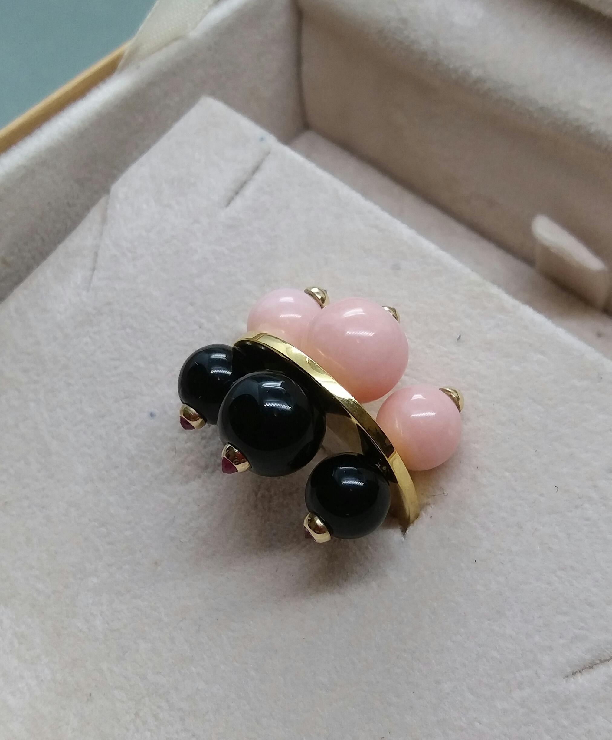 Unique and elegant Art Deco Style ring composed of a flat oval ring in solid 14 Kt yellow gold  with 3 round black onyx beads  with small faceted rubies set on one side and 3 pink opal beads with in the center 3 small faceted black diamonds set in