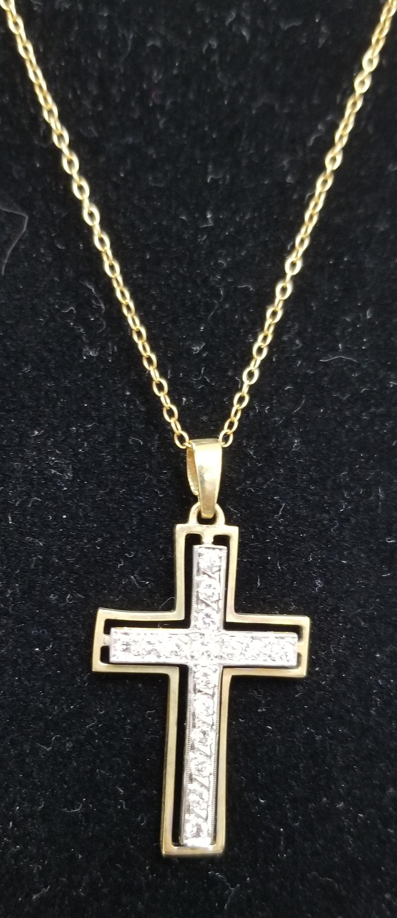 14k yellow gold cross with a 14k white gold insert cross with 16 round full cut diamonds of very fine quality weighing .50pts. on a 16 inch link chain.