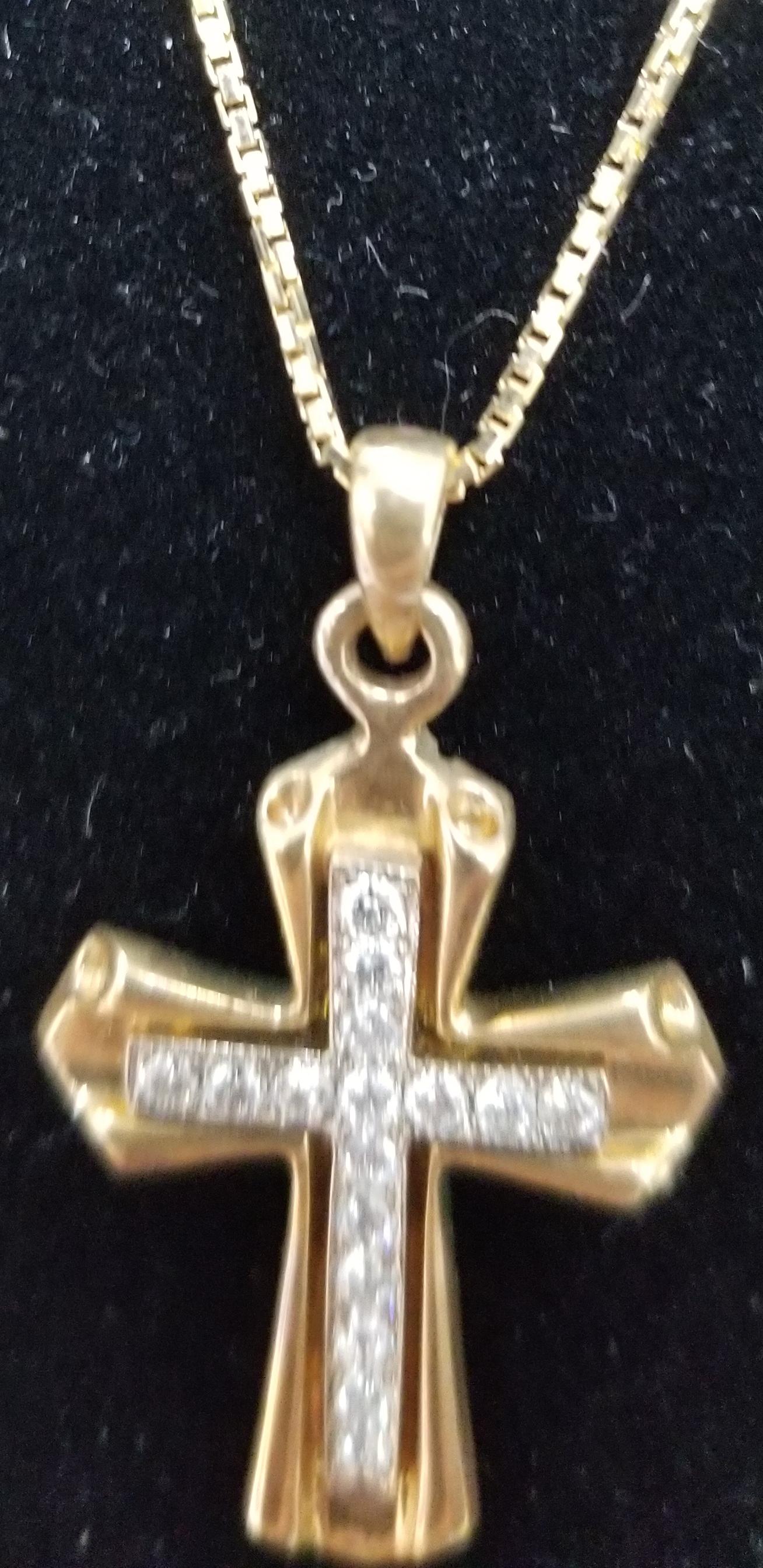 14k yellow gold cross with 14k white gold insert with diamonds of very fine quality weighing .15pts. on a 16 inch box chain.
Specifications: 
    Metal: 14kGold
    Weight: 5 Gr
    Main Stone: diamonds .15pts.
    Side Stones: 16 Diamonds    
   