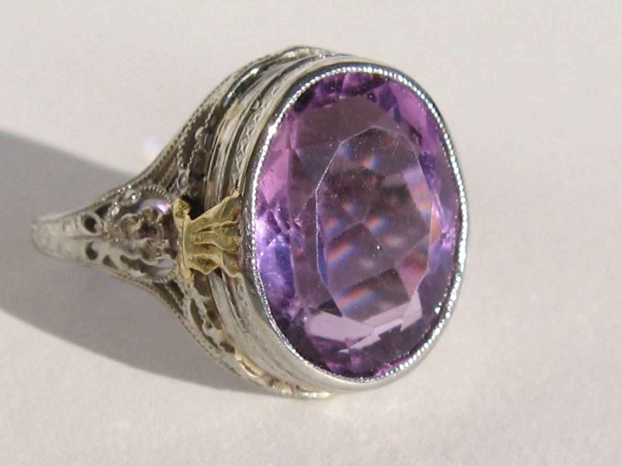 Stunning 14K Gold Filigree Amethyst 1920s Ring. Floral open work on both sides of the large amethyst stone. Stone measures 9.45 x 4.70 x 7.71 = 1.85 Carats. The ring is a size 6.75 and can be sized by us or your jeweler if needed. This is out of a