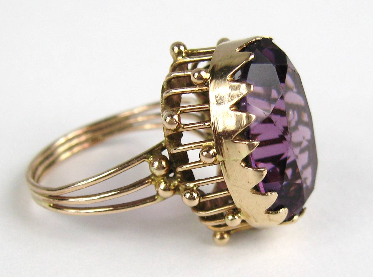 Stunning 14K Gold Setting with an oval Amethyst stone Approximately 9.25 Carats.  This sits up off you finger .45 in. The ring is a size 7.5 and can be sized by your jeweler or by us. This is out of a massive collection of New Old stock items as