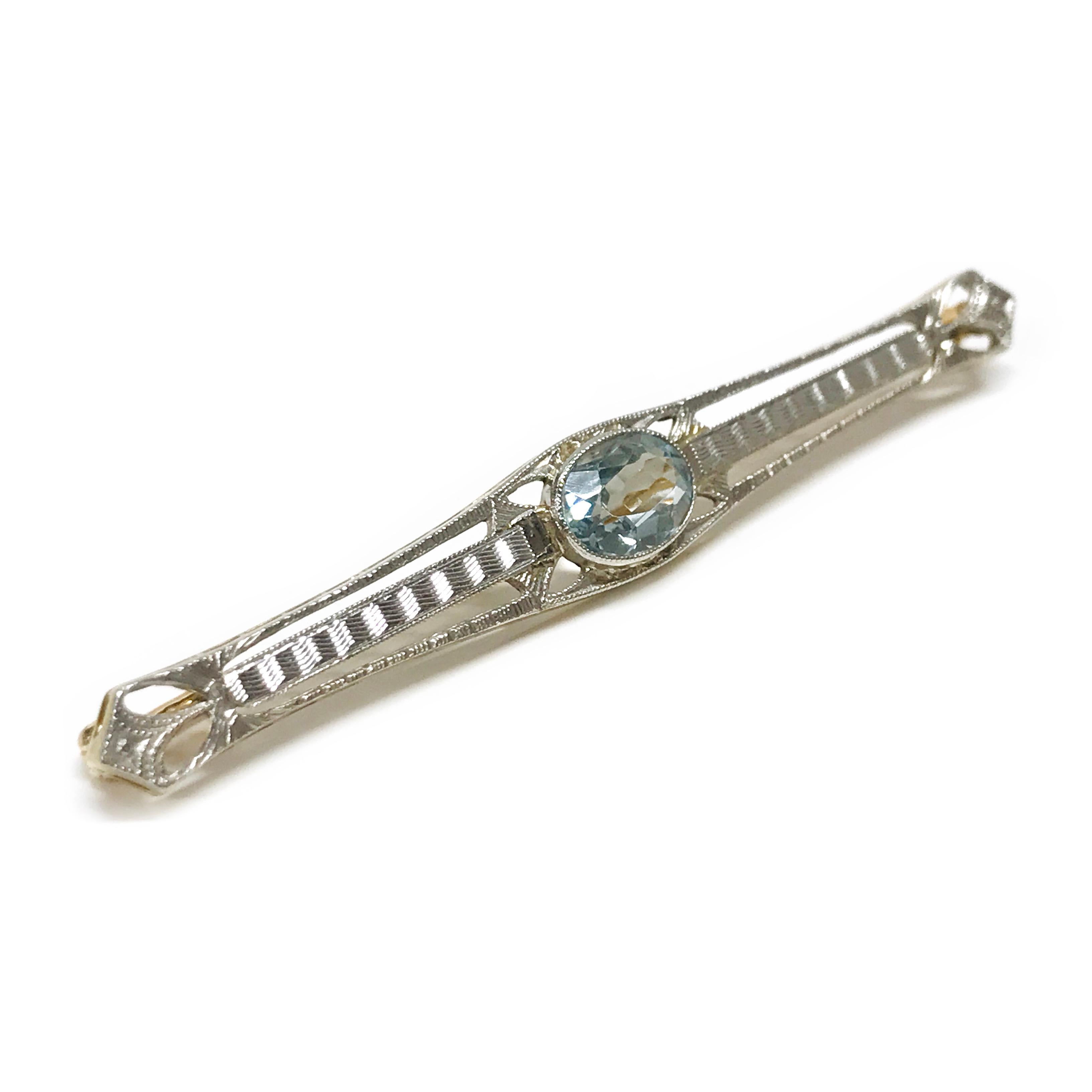 14 Karat Two-Tone Aquamarine Pin/Brooch. This is a special piece full of detail in both white and yellow gold. The 8x6mm oval-cut aquamarine is bezel set with milgrain detail. The total weight of the stone is 1.20ct. The pin/brooch measures 58 x