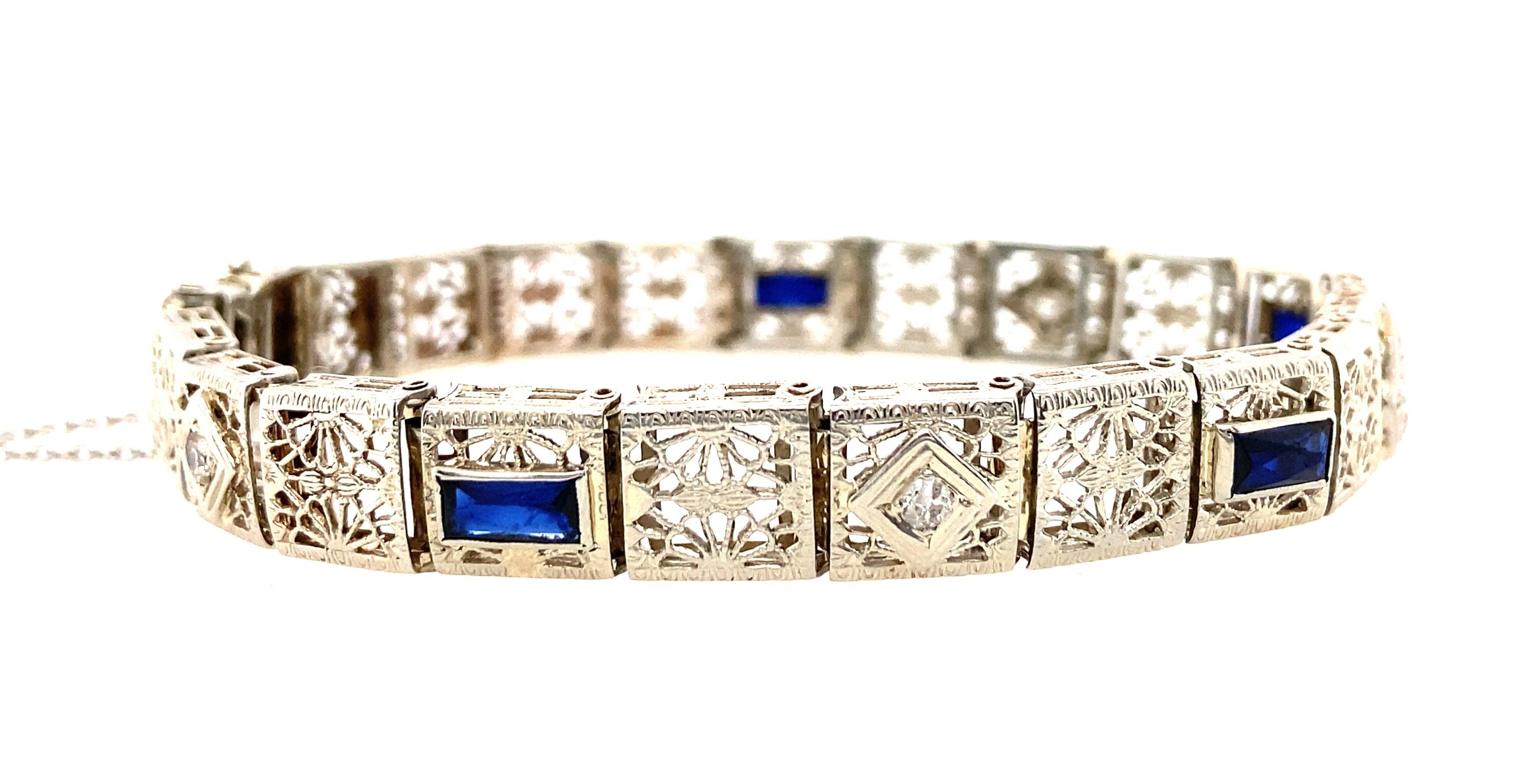 Dieses Armband aus 14-karätigem Art-Déco-Weißgold mit vier leuchtend blauen, rechteckigen synthetischen Saphiren zeigt die modernen Schmuckwunder der damaligen Zeit - Weißgold und synthetische Saphire. Für zusätzliches Funkeln sind 0,10 tcw