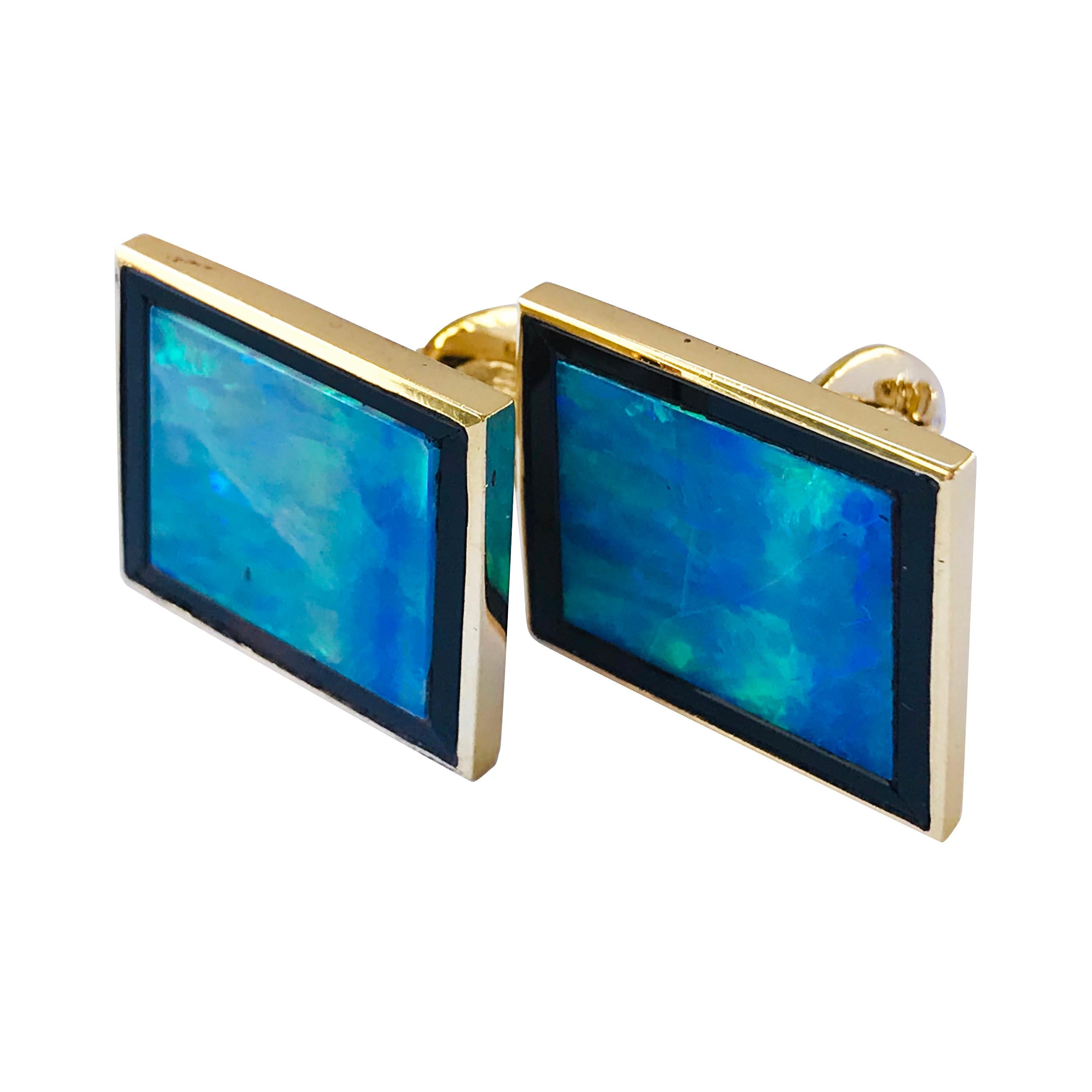 14 Karat Australian Black Opal Rectangular Cufflinks. The fronts feature a rectangular Black Australian Opal bezel-set with a black Onyx surround. Quality is A: Dark grey to black background, good to medium play of color with at least two