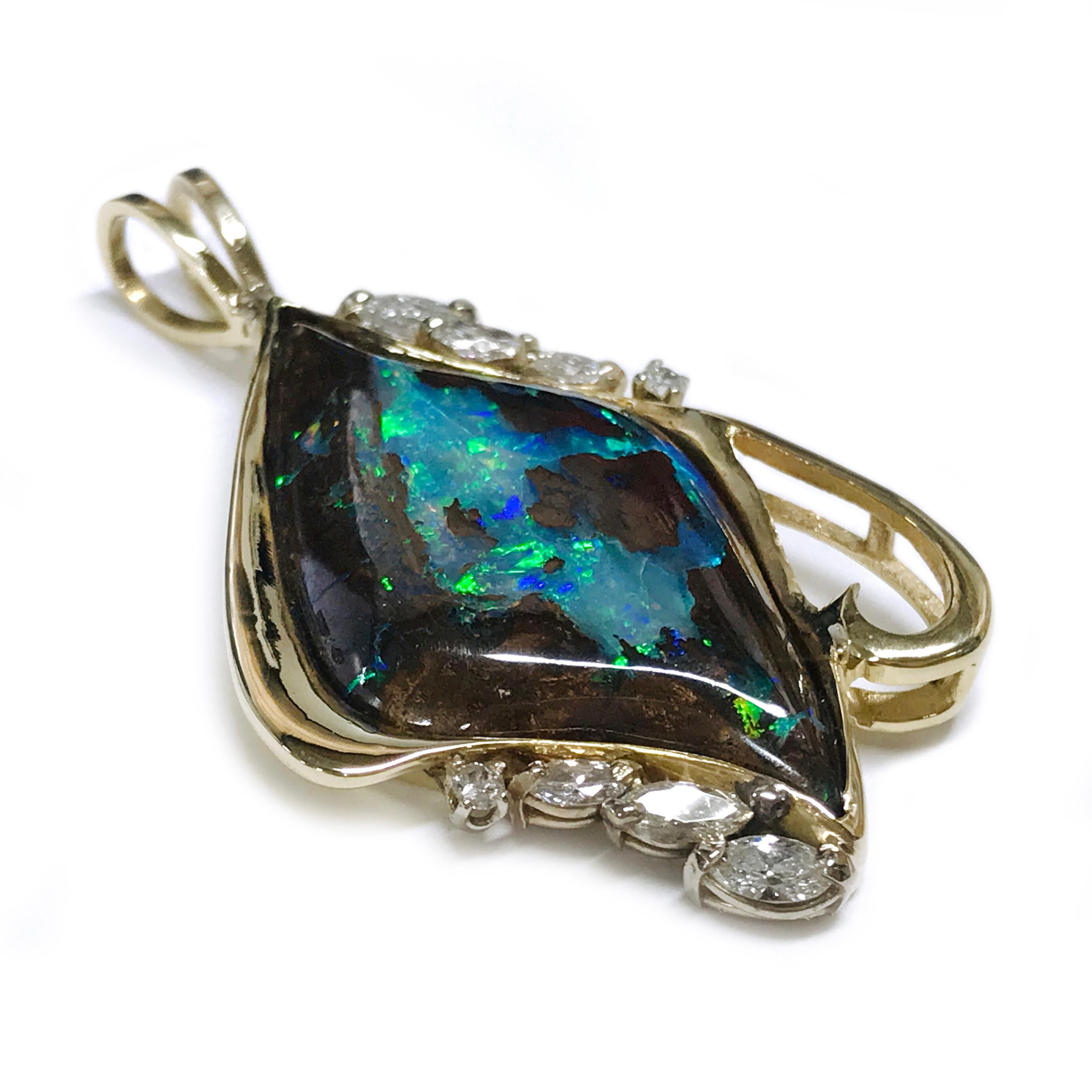 Questo splendido ciondolo presenta una maestosa opale nera incastonata in un castone a forma di diamante, elegantemente incorniciato da intricate volute d'oro. La combinazione di diamanti marquise e rotondi esalta la bellezza dell'opale, creando un