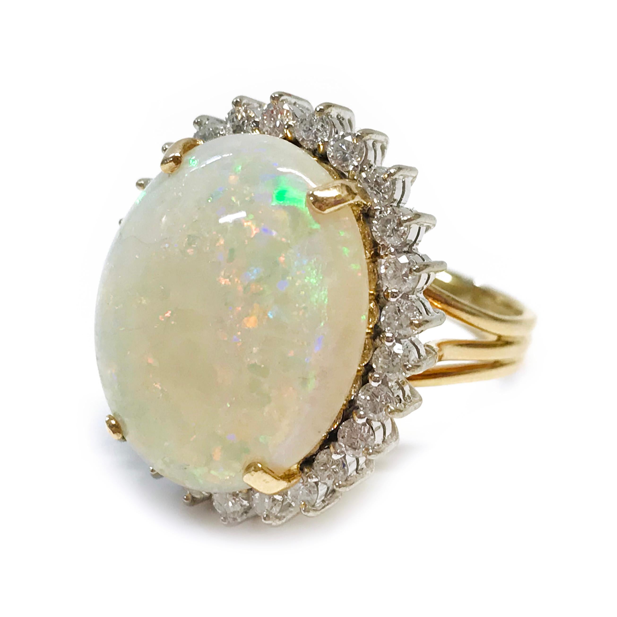14 Karat Australian Opal Cocktail Ring with a Diamond Halo. The split band adds elegance and detail to the ring and compliments the 10.28ct Opal. The Opal cabochon measures 19 x 15.5mm and has beautiful variations of red, green, and purple colors.