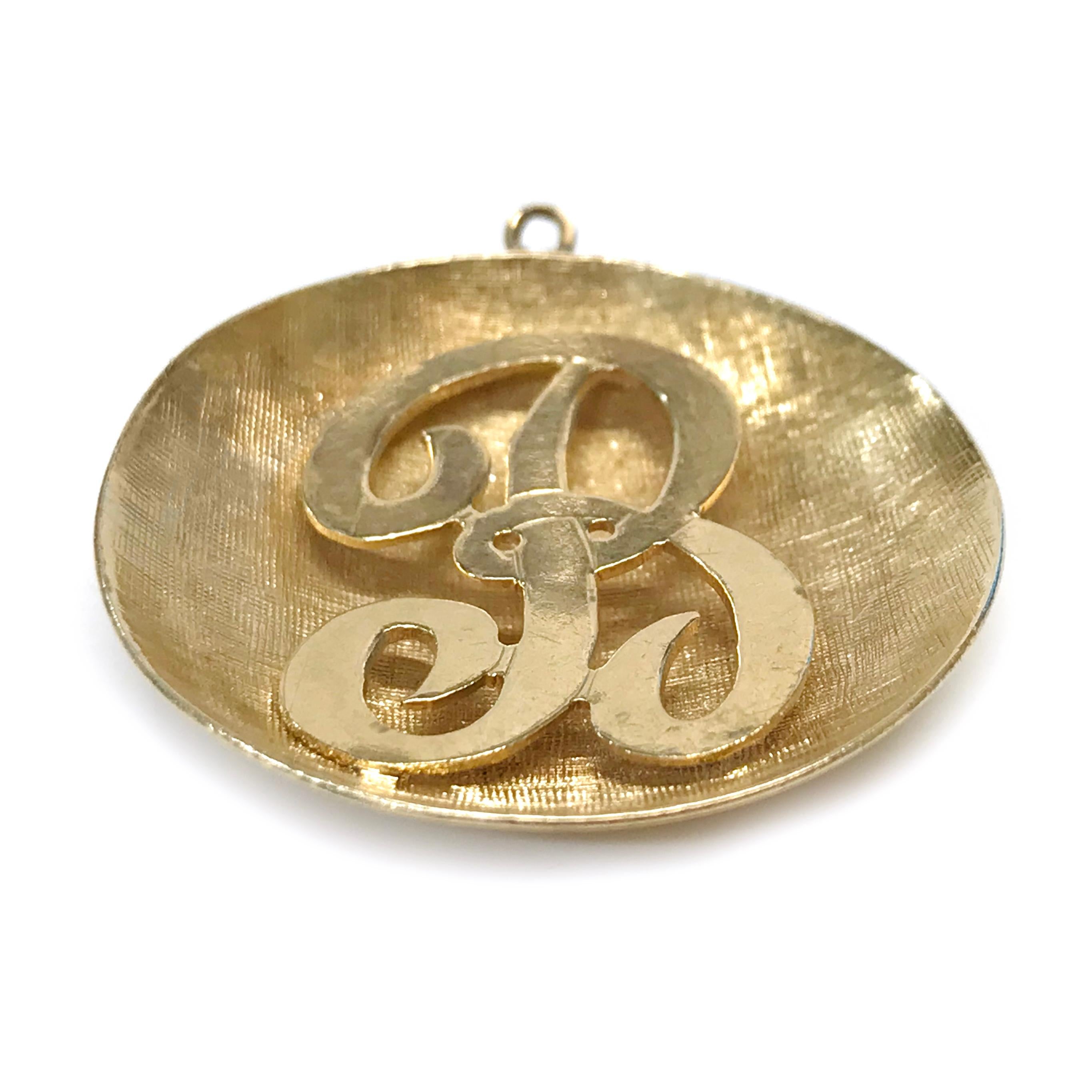 14 Karat B Initial Pendant. The pendant measures 30.2mm in diameter. The front of the disc-shaped pendant has a herringbone texture with a cursive letter B in the center. Engraved in cursive on the back is For Bea Sydell & Norman 4-61. The total