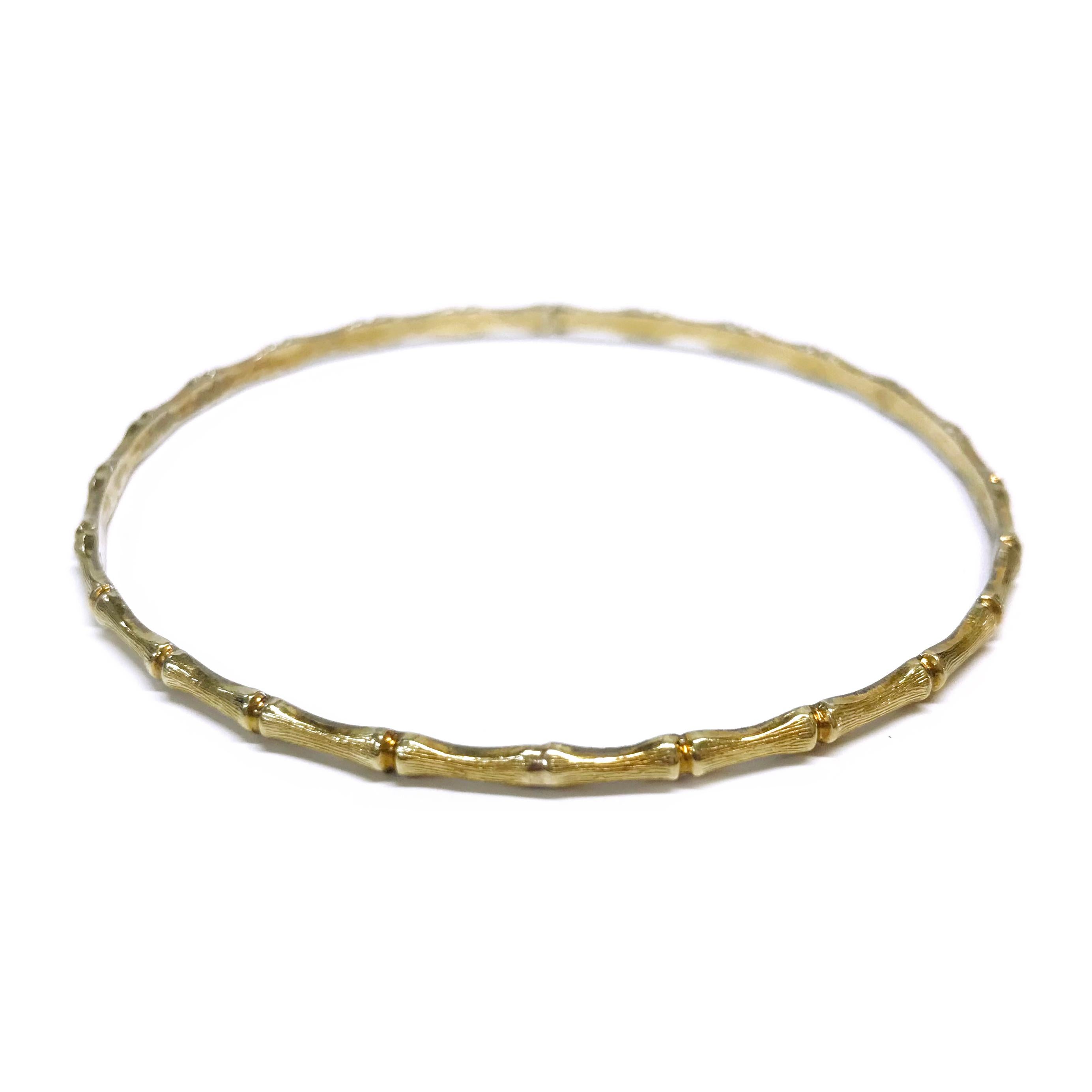 14 Karat Yellow Gold Bamboo Bangle. The bangle consists of textured bamboo sections on the exterior of the bangle and a smooth flat surface on the interior of the bangle. The bangle measures 1mm x 2.75mm with a 7.5