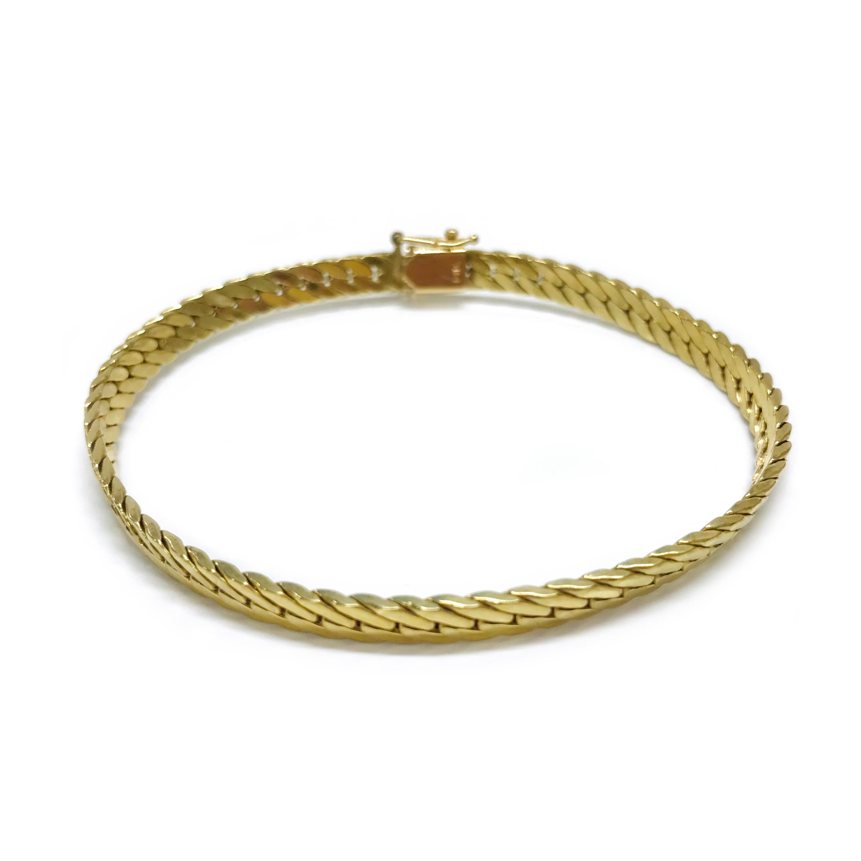 14 Karat Link Bracelet Bangle. This bracelet features beveled herringbone links. The bracelet a flexible when not closed however when the bracelet is closed it stiffens (see photos) and is not flexible. The bracelet is 5mm wide and 7 1/2