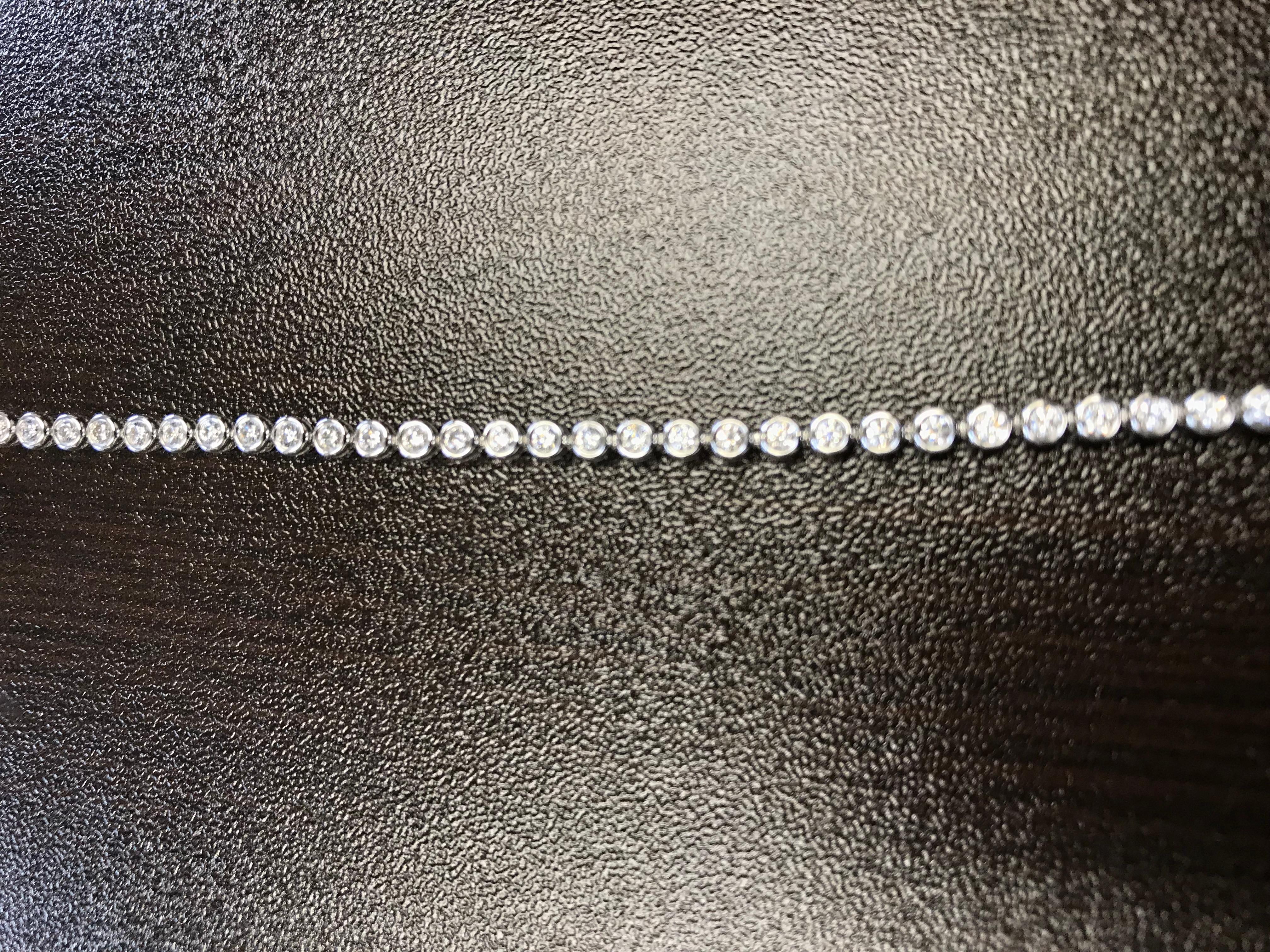 Bezel set tennis bracelet set in 14K white gold. These excellent cut diamonds are G color, SI1-SI2 clarity. The total carat weight of the bracelet is 1.35. The price is 3,450.