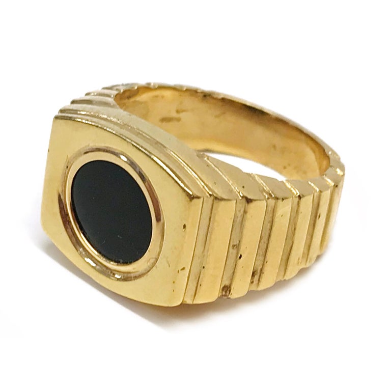 14 Karat Black Onyx Ring. The ring features a bezel-set flat circle black onyx. The Onyx 10mm and the ring size is 9.5. There are raised ridges starting at the top of the band and ending near the bottom of the band. The total gold weight of the ring