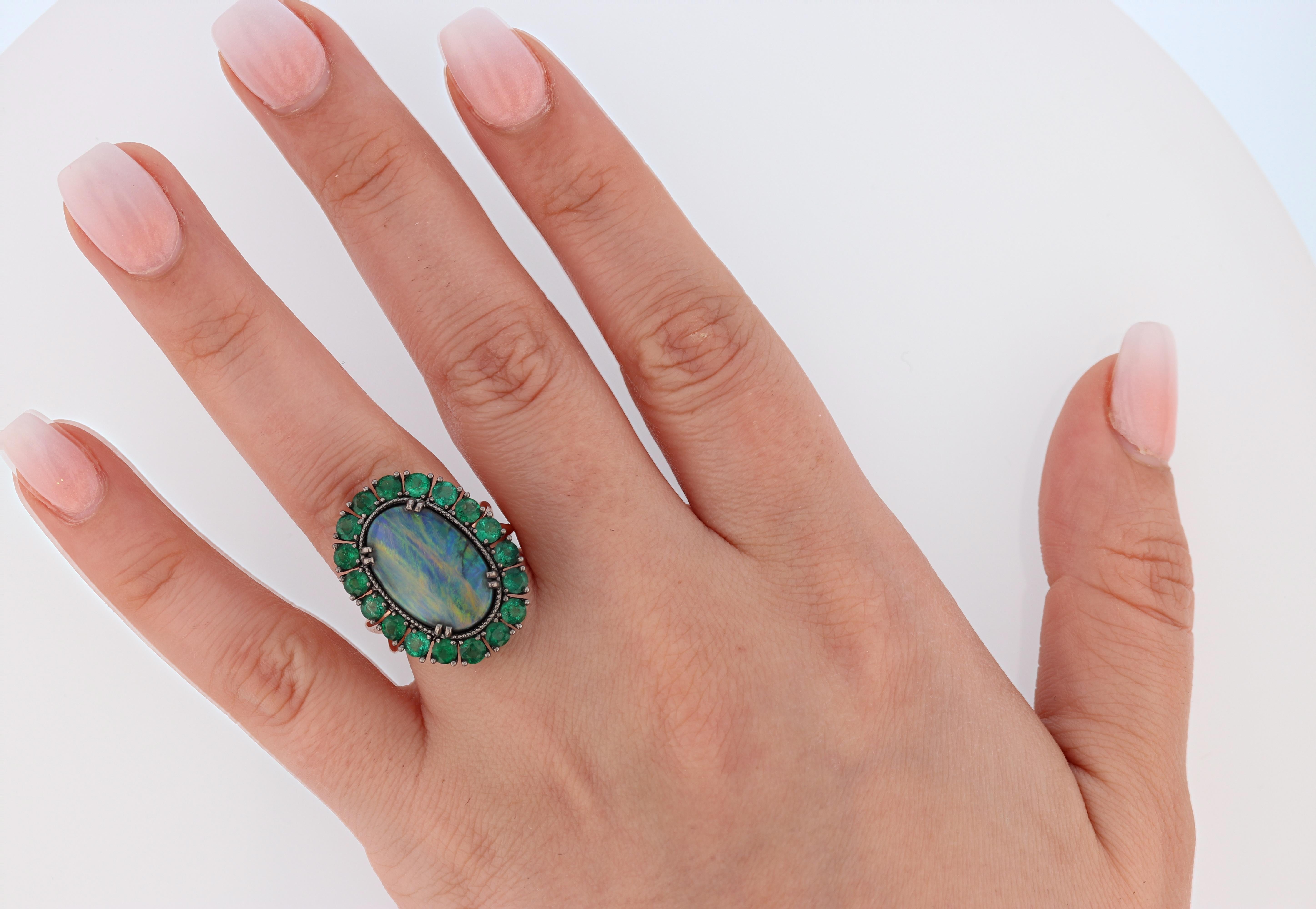 This ring is made with 14 karat rose gold and 14 karat white gold that has a black rhodium finish and features a 4.30ct Australian black opal with a mixture of colors like blue, green, orange and yellow and is surrounded by 18 prong set round cut