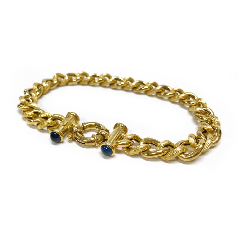 14 Karat Blue Sapphire Cuban Link Bracelet. The bracelet features 8mm alternating ridged and shiny finish curbed links. The bracelet is 8
