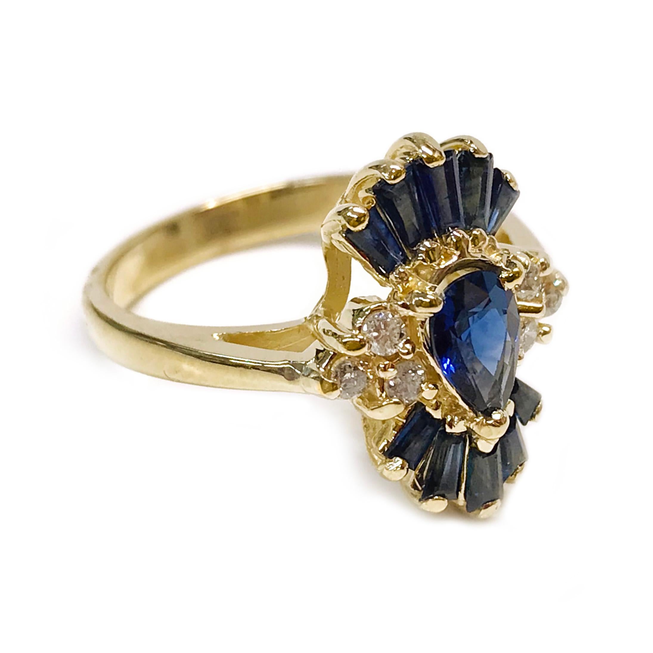 14 Karat Blue Sapphire Diamond Ring. The ring features a center pear-shaped blue sapphire with three round diamonds on either side and five baguette blue sapphires on the top and bottom. The total carat weight of the center sapphire is 0.54ct. The