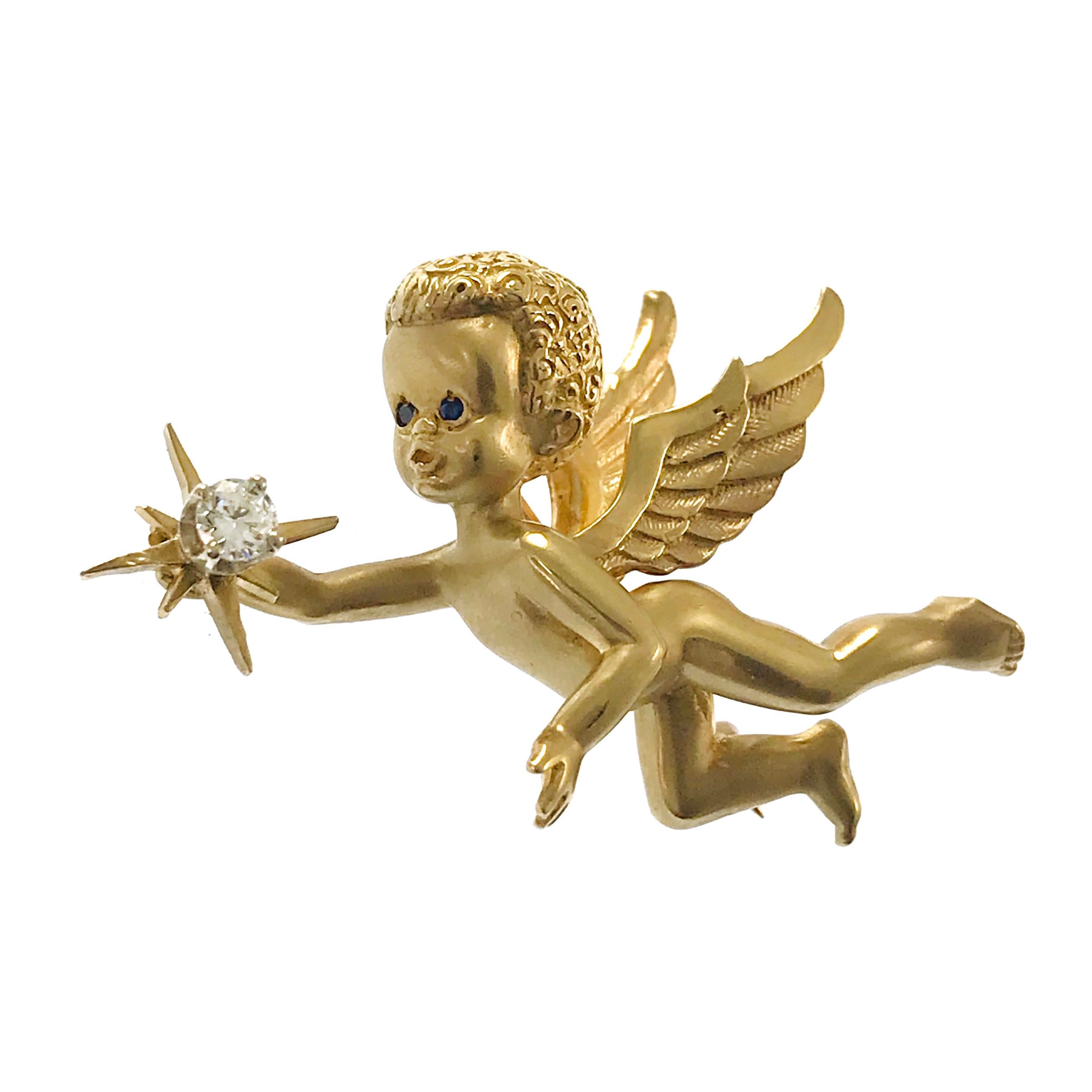 14 Karat Cherub/Angel Brooch Pin. This adorable little fellow will captivate you with his blue sapphire eyes and sparkly diamond star. The round 3.25mm diamond is VS1 in clarity (G.I.A.) and G-H in color (G.I.A.) and is a total carat weight of