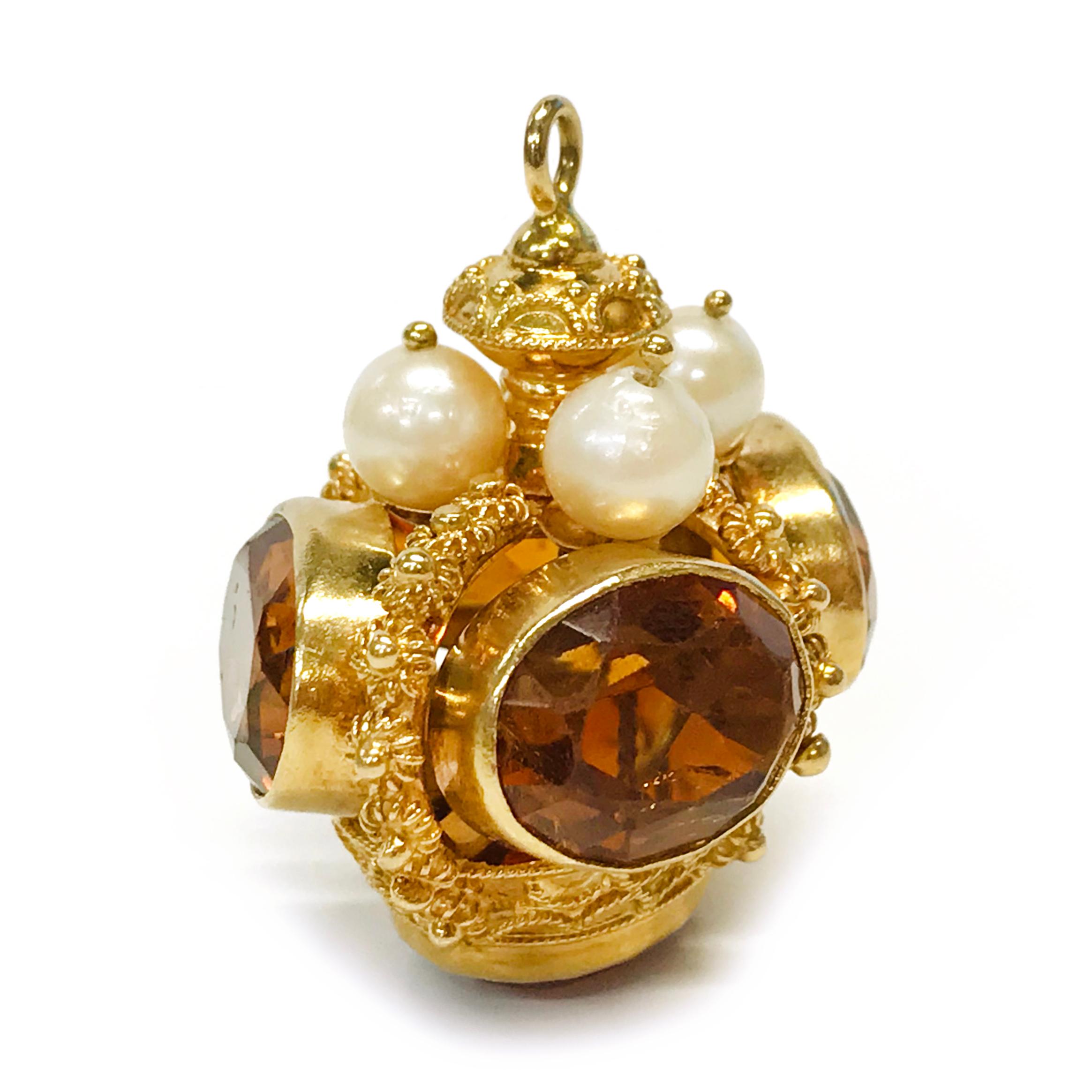 14 Karat Citrine Pearl Crown Pendant. This glorious crown pendant has lovely gold detail and features five oval-cut citrines bezel-set around the crown and at the bottom. The crown measures 32.67mm wide by 35.45mm tall. On the top of the crown under