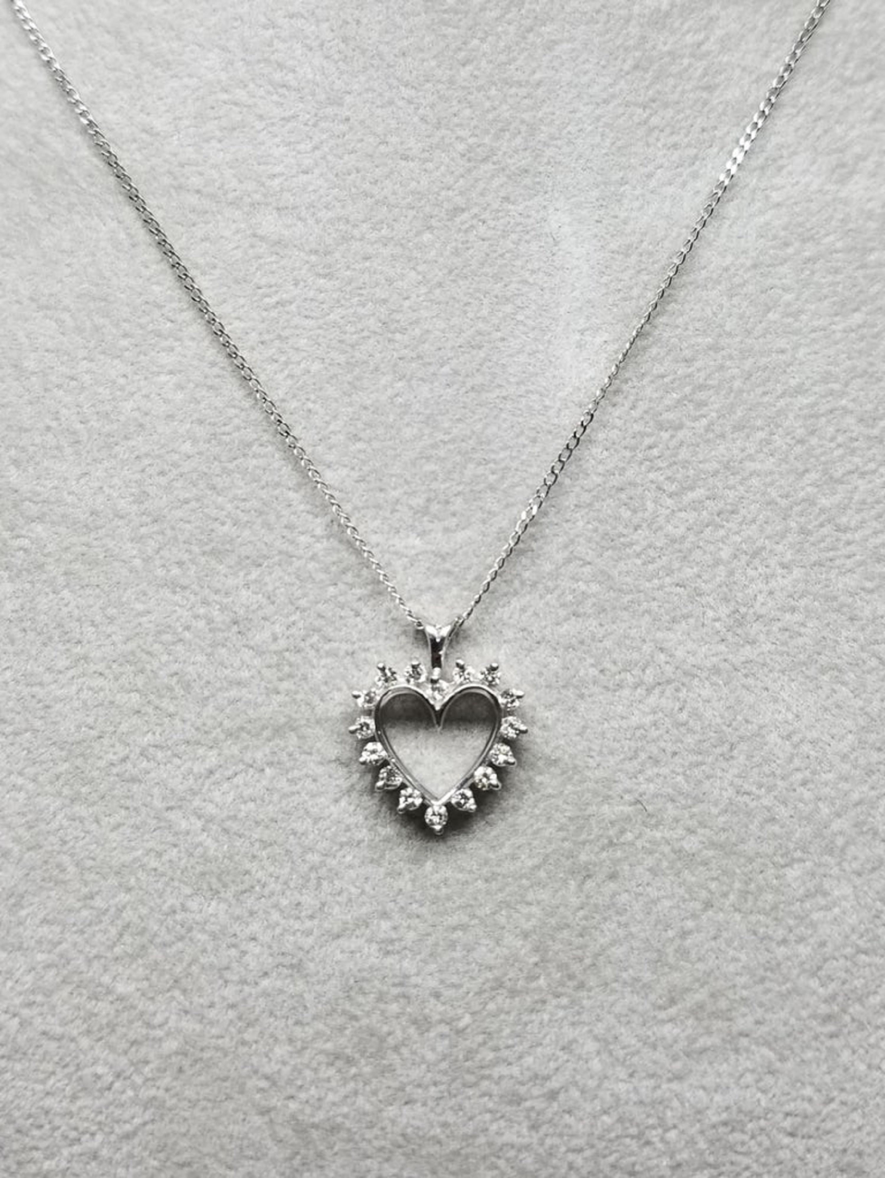 14k white gold diamond heart pendant containing 16 round full cut diamonds of very fine quality weighing .25pts. on a 16 inch chain.