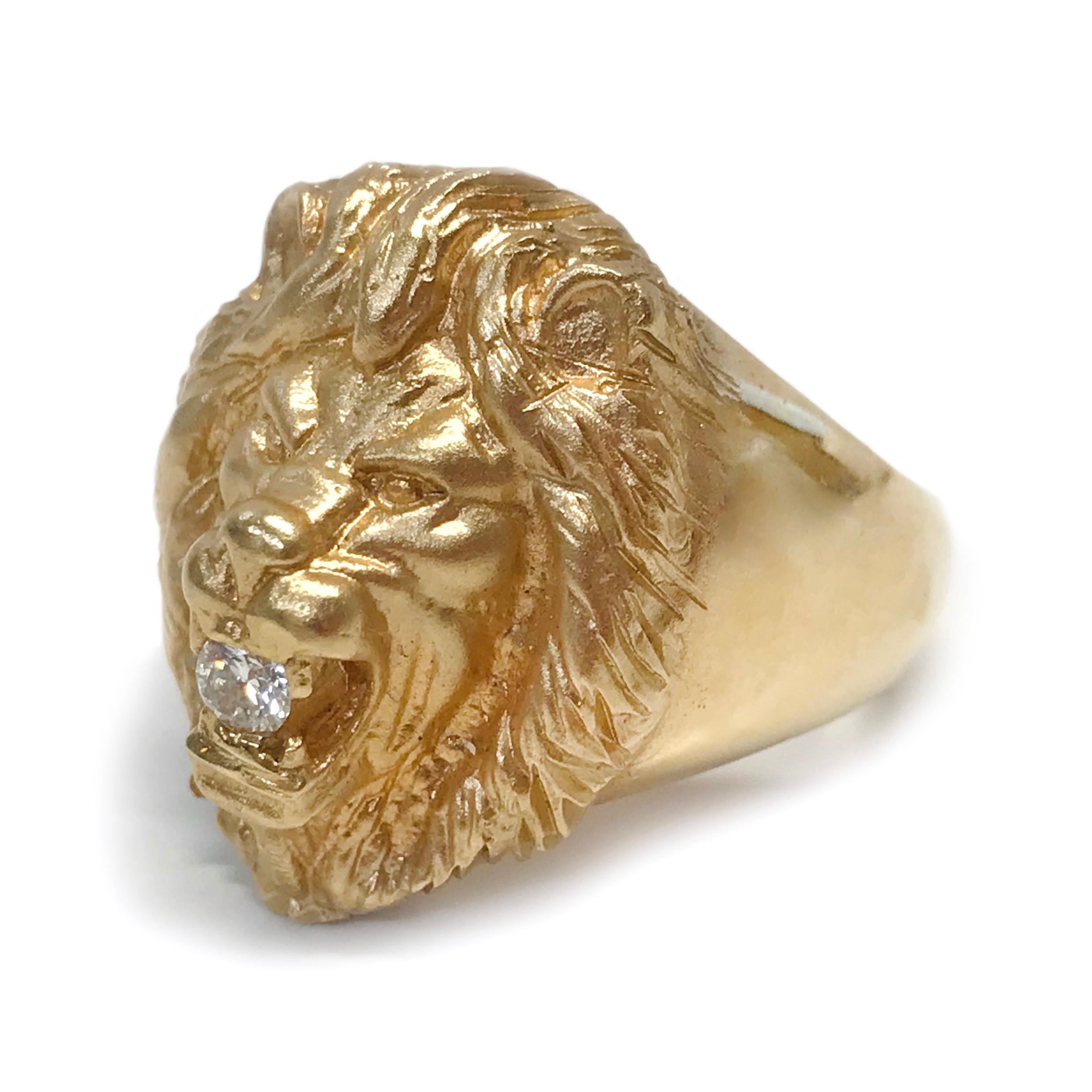 14 Karat Yellow Gold Diamond Lion Ring. This glorious ring features a detailed lion head and mane in a satin finish with a diamond set in the open mouth. The rest of the wideband tapers with a smooth finish. The round diamond has a total weight of