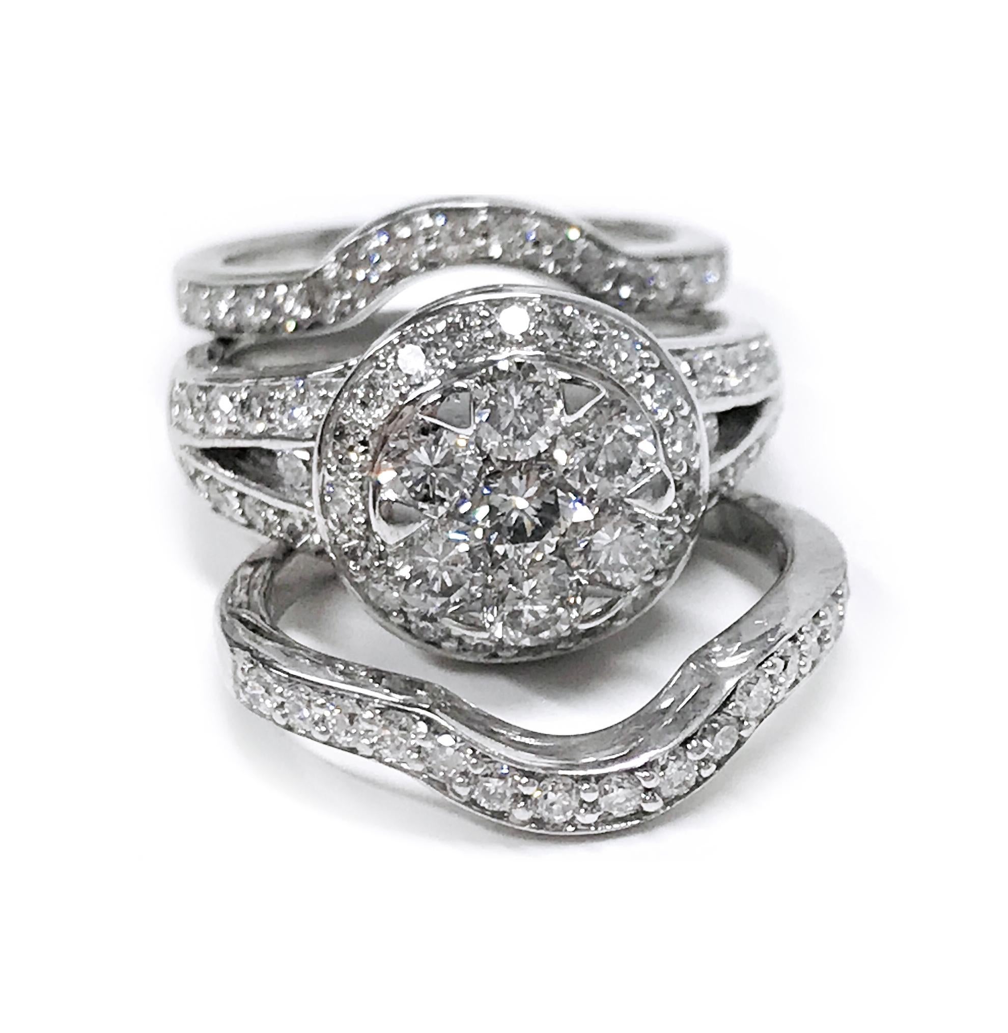 14 Karat White Gold Diamond Triple Ring Set. The middle split band ring has seven round diamonds set in the center with a halo of nineteen diamonds and eighteen side diamonds. The diamonds are VS2-SI1 (G.I.A.) in clarity and G-H (G.I.A.) in color.