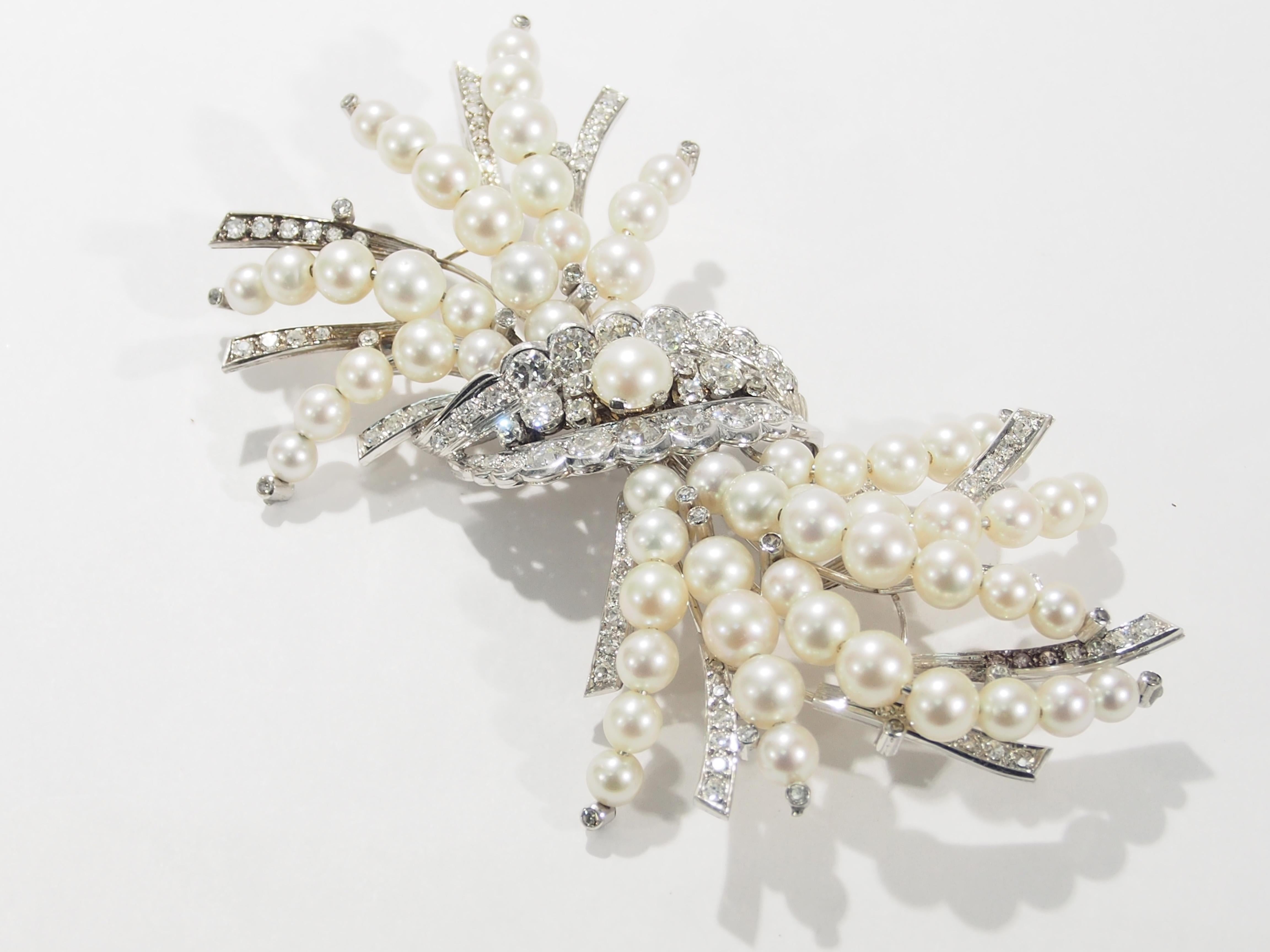 This is a stunning 14K White Gold Brooch containing Diamonds and Pearls. A fascinating Brooch from the Edwardian Period that is designed as a spray of flowers formed by Pearls and Diamonds in a 4 inch length by 2 inch width. There are 126 Old