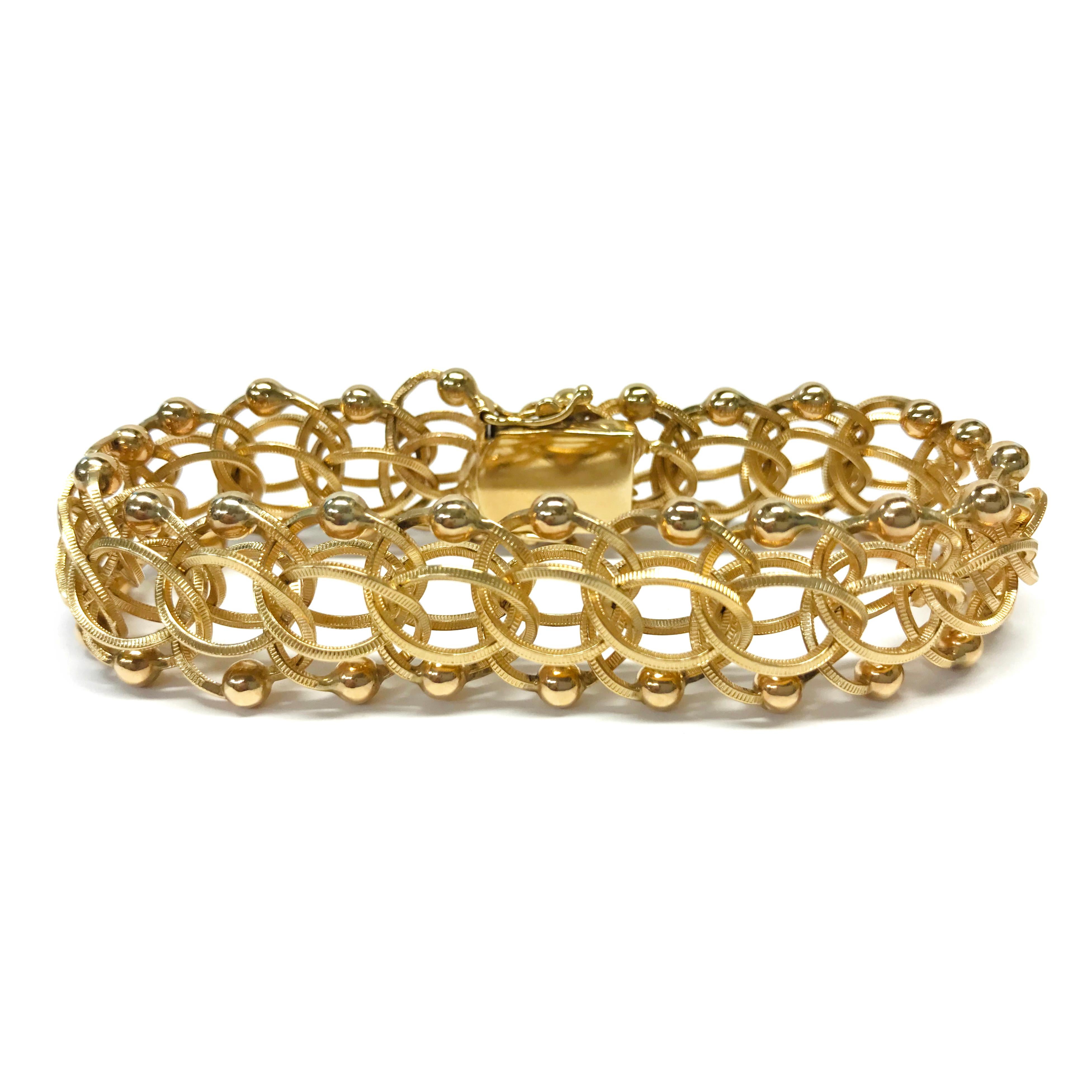 14 Karat Fancy Link Charm Bracelet. This unique bracelet features multiple textured links, one with a round gold bead, all linked together to create a fabulous layered look. The bracelet is 15.5mm wide, 8.5