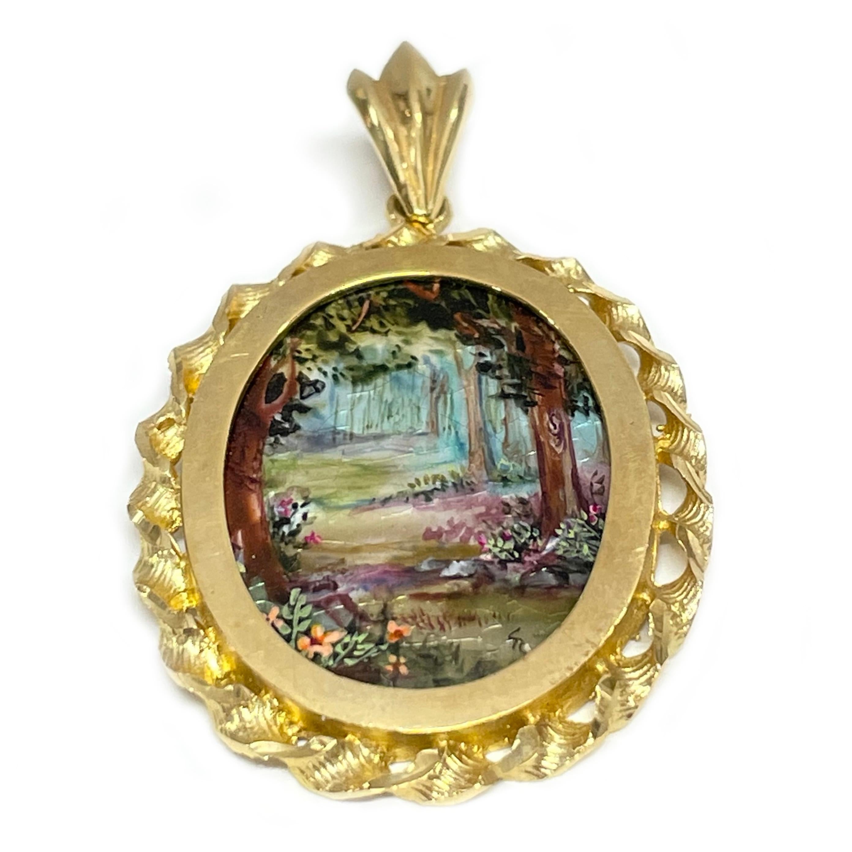 14 Karat Yellow Gold Forest Hand Painted on a Mother of Pearl Pendant. The miniature painting is set in a 14 karat gold twisted rope oval frame with diamond-cut details. The painting is signed by the master artist, CR Charlotte and includes a