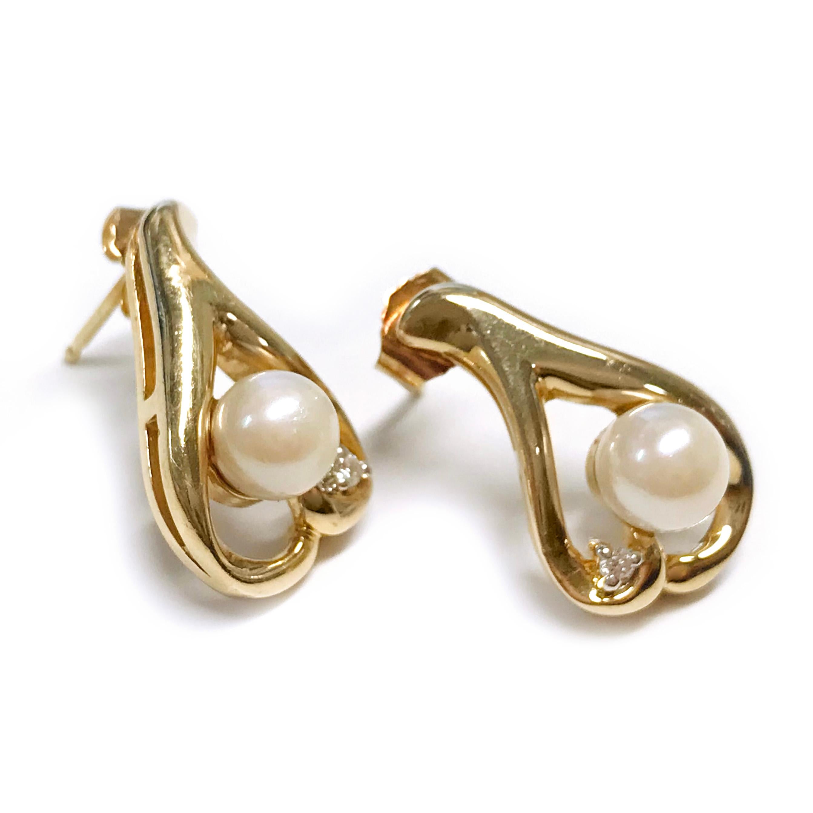 14 Karat Freshwater Pearl Diamond Earrings. Each earring features a freshwater Pearl and diamond set on a double swoosh that forms a teardrop. The two 6.5mm Pearls are A grade: cream, pinkish; lightly blemished; good shape; good luster. Two melee