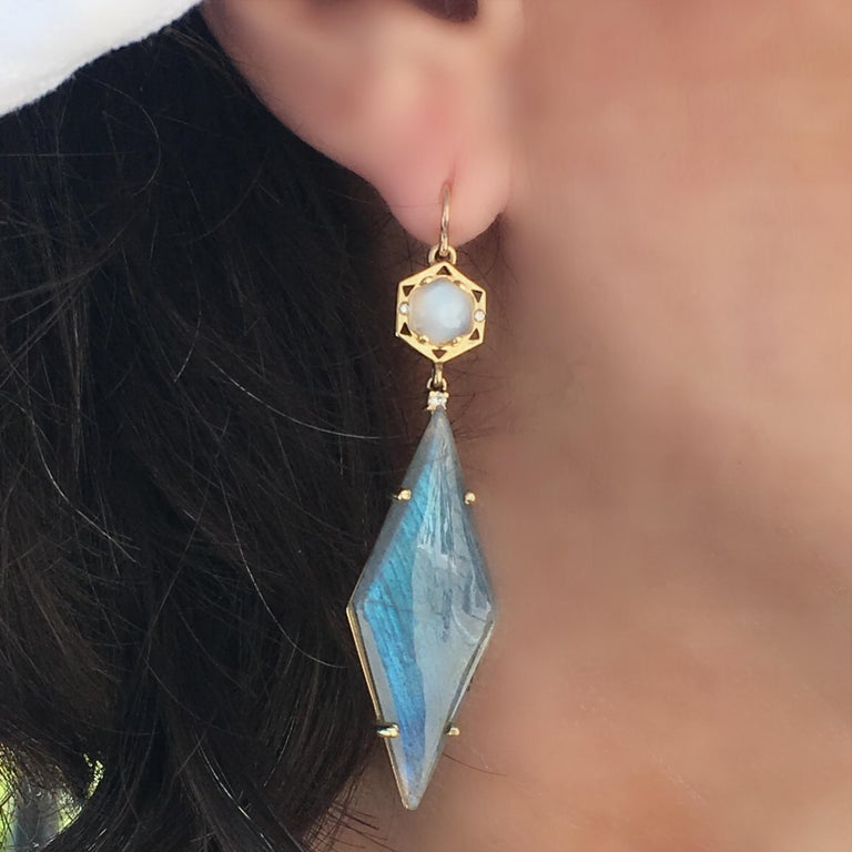 Drama is the mood created when wearing this long, geometric earring.  Featuring a Moonstone hexagon cabachon set in gold with a sprinkle of diamonds along with a long kite shaped Labradorite. This earring is fashionable and can be worn both casual